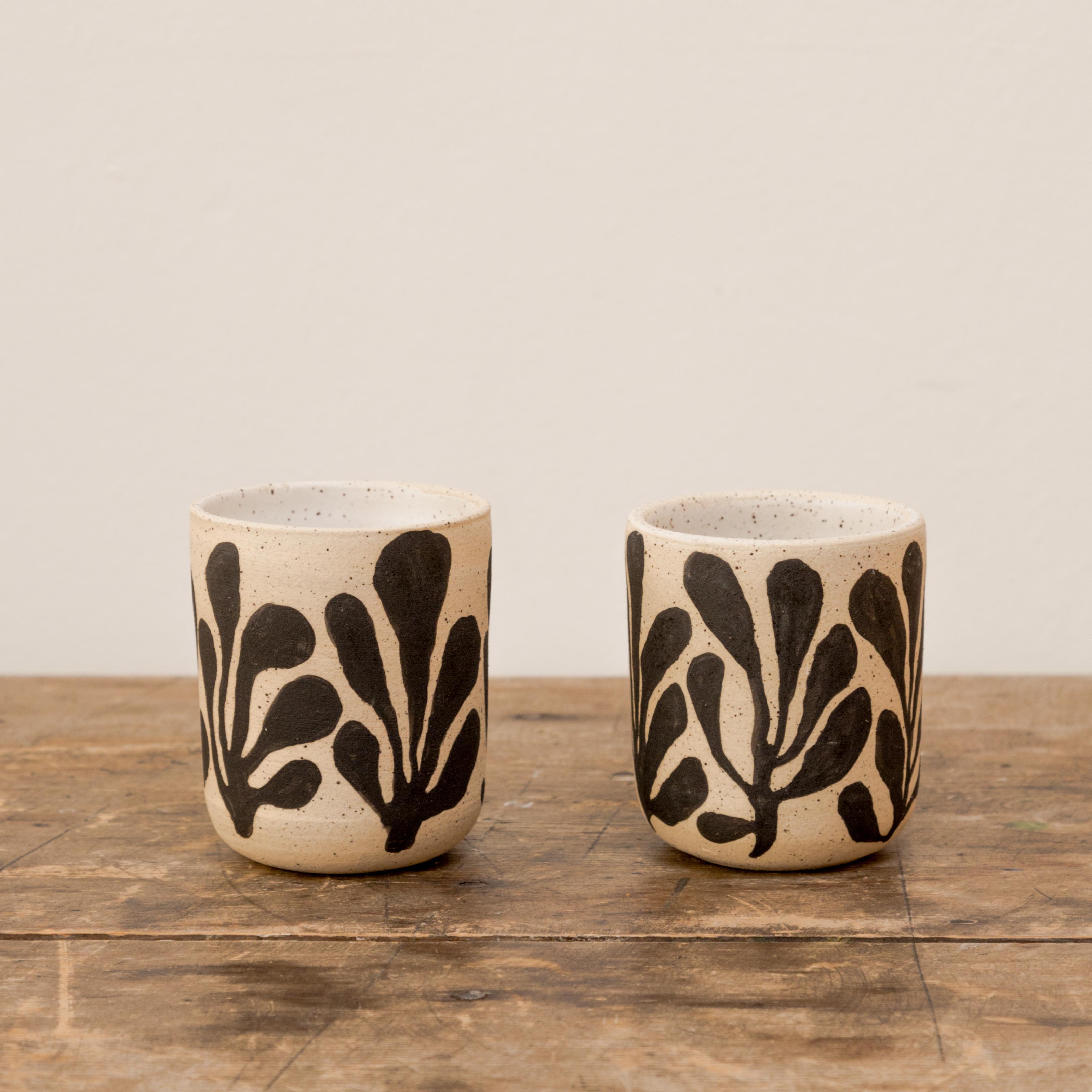 Pair of small ceramic vessels with botanical graphic by Kaila Medina (Sold individually).