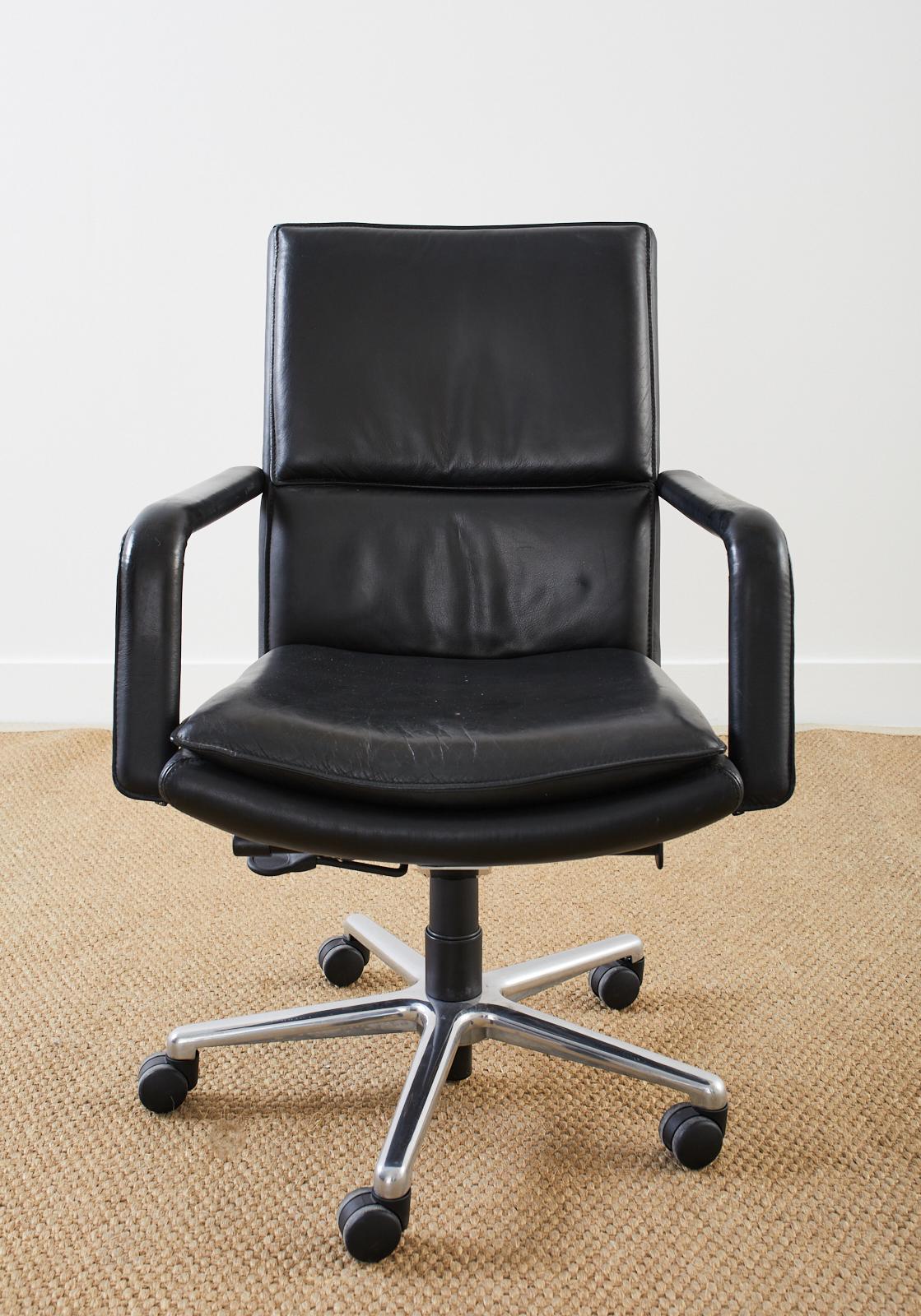 Modern executive office desk swivel armchair made by Keilhauer. Model number 597-5 finished in black leather upholstery with a five star polished steel base. Mid back height office chair with pneumatic height adjustment and tilt. Very comfortable