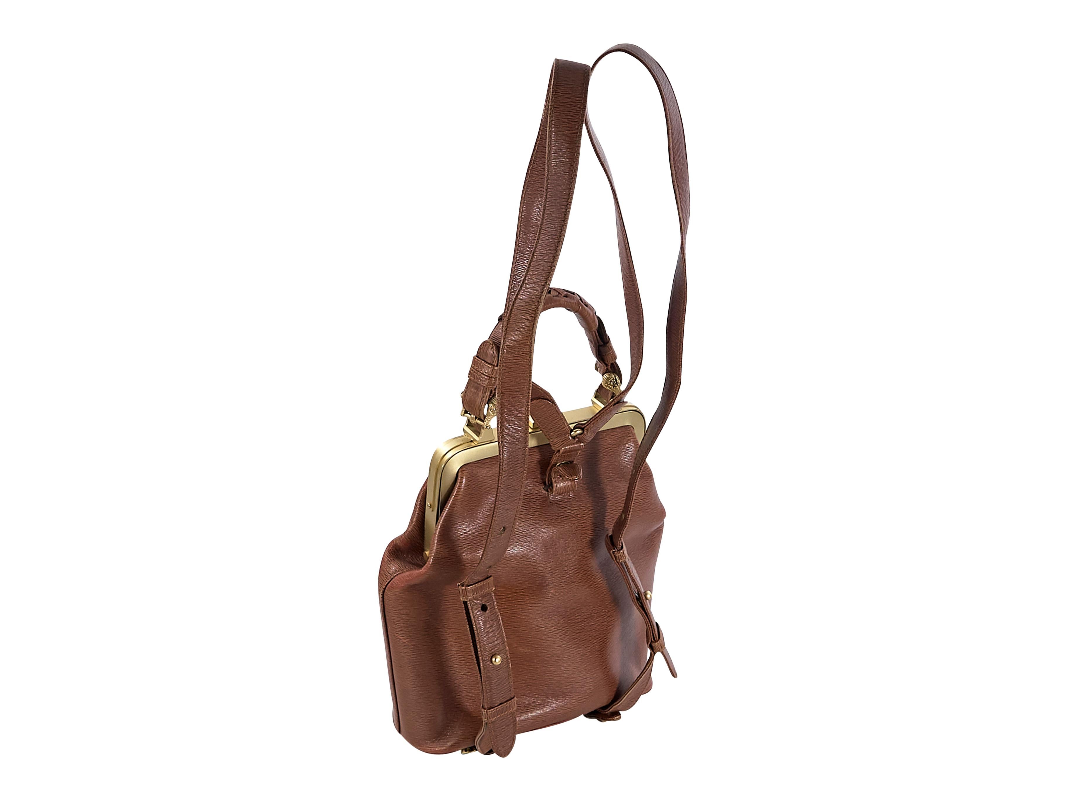 Product details:  Brown convertible leather backpack by Keiselstein-Cord.  Top carry handle.  Adjustable shoulder straps.  Top push-lock closure.  Accented with an alligator charm.  Lined interior with inner slide pockets.  Goldtone hardware. 