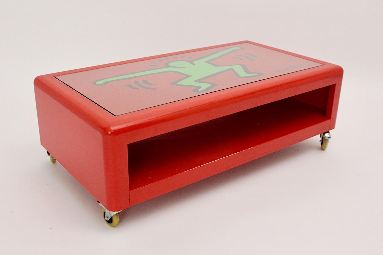 Pop Art Keith Haring ( after ) low sofa table of coffee table from metal in red and green color by Bretz circa 1998, Germany.
A Keith Haring low sofa table by Bretz from red lacquered metal with wheels and two tiers, sweet boy graffiti motif in