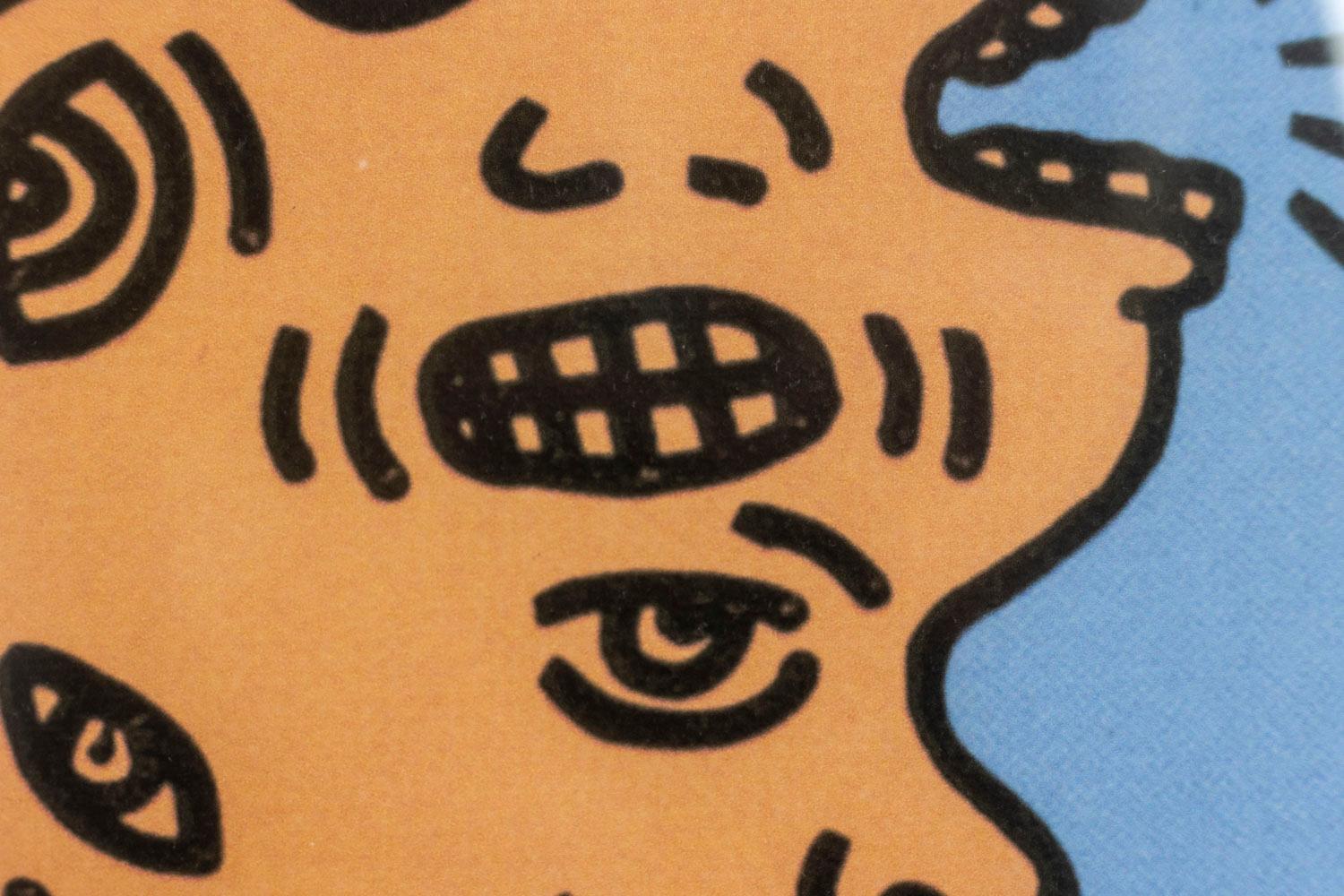 Keith Haring, signiert und nummeriert.

Lithografie, die ein Gesicht mit mehreren Köpfen in Lachstönen auf blauem Grund darstellt, in einem Rahmen aus blonder Eiche.

Amerikanische Arbeiten aus den 1990er Jahren.