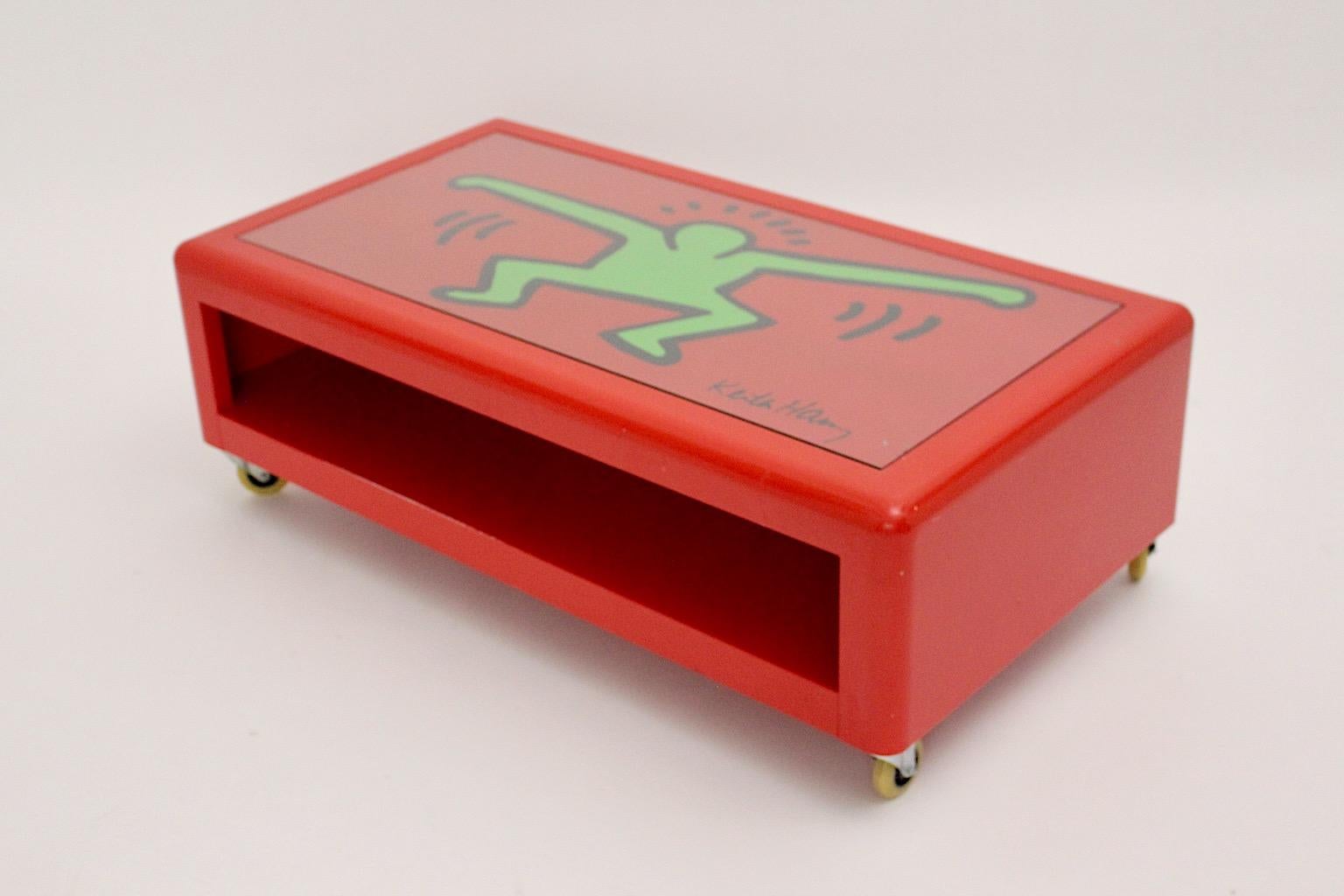 Pop Art Keith Haring ( after ) low sofa table of coffee table from metal in red and green color by Bretz circa 1998, Germany.
A Keith Haring low sofa table by Bretz from red lacquered metal with wheels and two tiers, sweet boy graffiti motif in