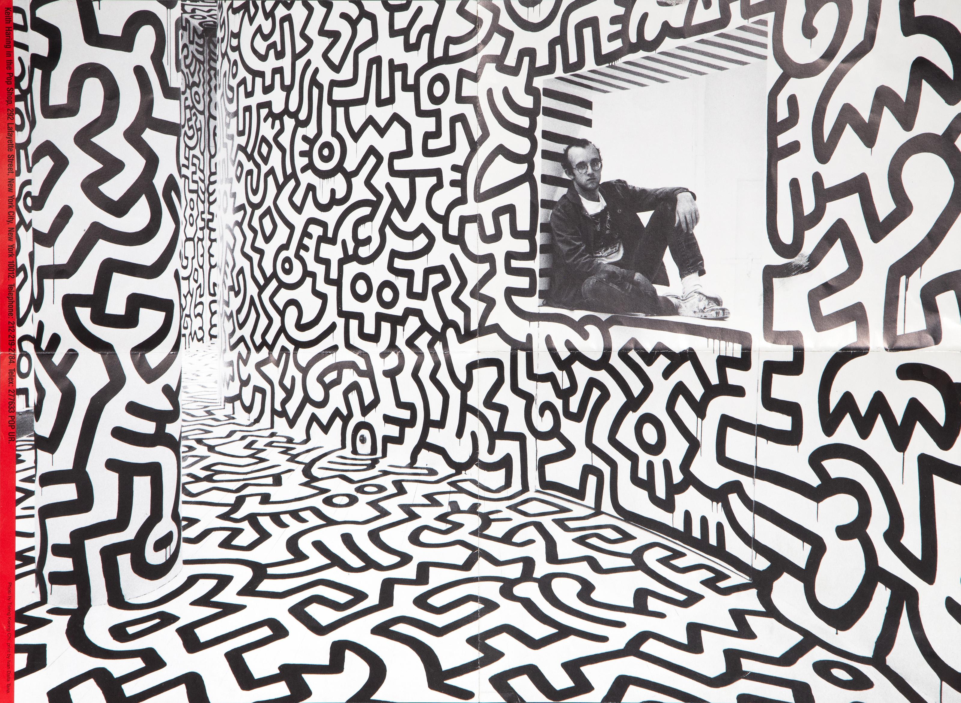 This poster shows American Pop artist Keith Haring sitting in the checkout window of his pop up shop, a space entirely covered ceiling to floor with black line illustrations in Haring’s style. On the reverse of this poster are images of the