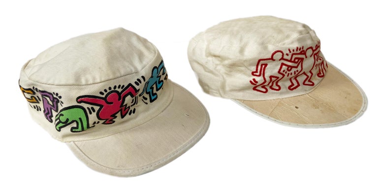 Vintage original Keith Haring Pop Shop hats designed & illustrated by Haring c. 1984-1987:

Embroidered painters hats (set of 2). 10 x 8 x 3 in. (25.4 x 20.3 x 7.6 cm.).
Fair overall vintage condition signs of age and use throughout.
Printed
