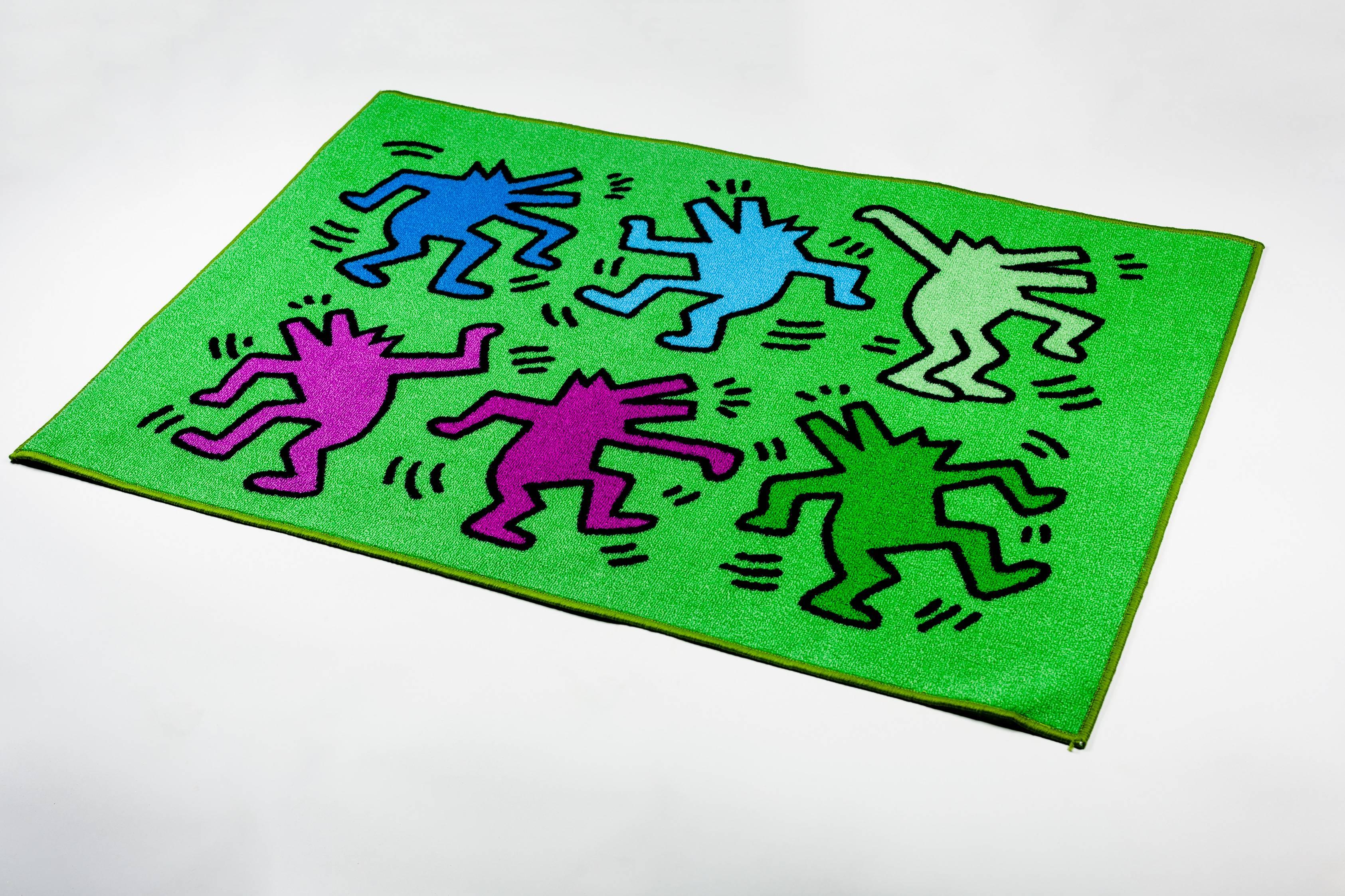 Brilliant colors green, blue and purple on this 32x47in Keith Haring rug depicting six dancing dogs, distributed by Comart Italia. Copyright Keith Haring Foundation, licensed by Artestar, New York. New old stock, in packaging. For anyone who admires