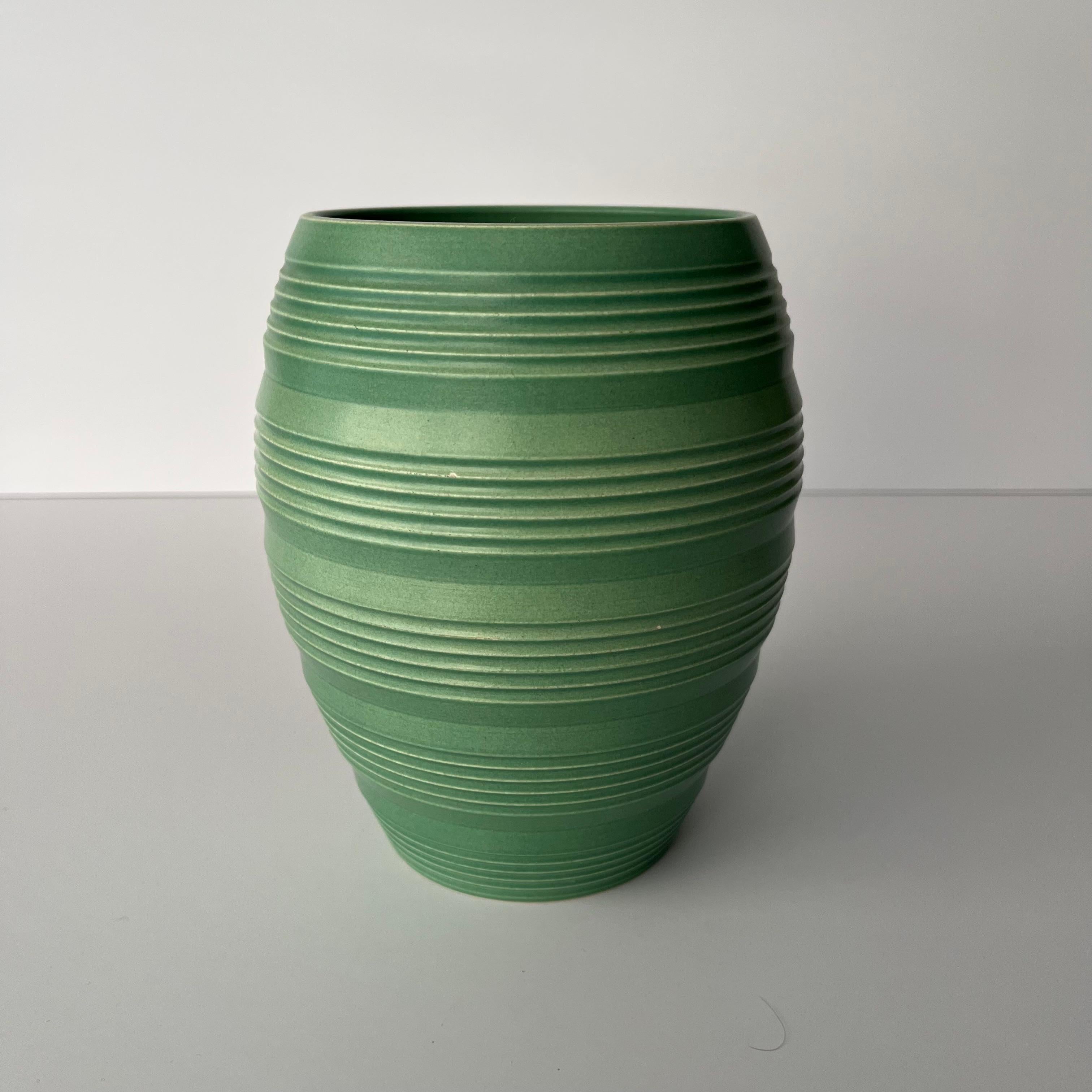 Keith Murray Vase von Wedgwood, Modellnummer 3868.

Eine schöne grüne, matt glasierte Steingutvase mit handgedrehten Rillen und eingeschnittenem, gebändertem Kreisdekor.
Eingedruckte und gedruckte Fabrikmarken mit Keith Murrays Unterschrift auf dem