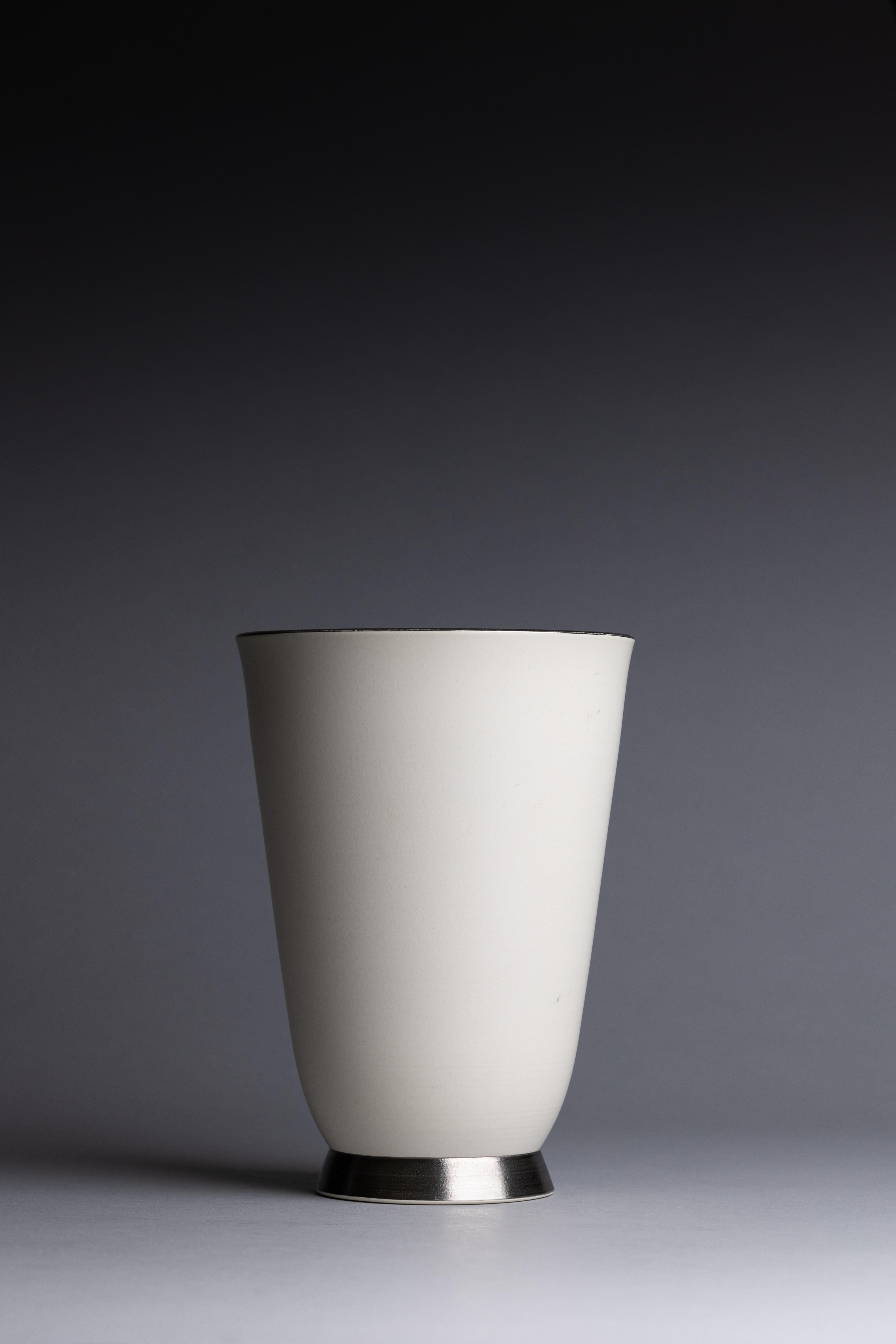 Vase des années 1930 de Keith Murray pour Wedgwood, avec un extérieur émaillé de pierre de lune et un intérieur vert mat, accentué par des détails en platine autour du bord et du pied.

Dimensions : 9 1/4 in. H x 6 1/2 in. Dm
État :