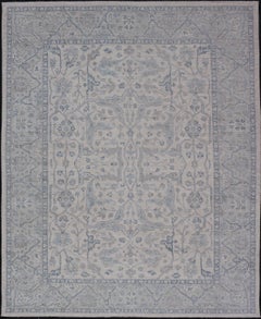 Keivan Woven Arts Oushak moderno sobre fondo crema claro y diseño azul