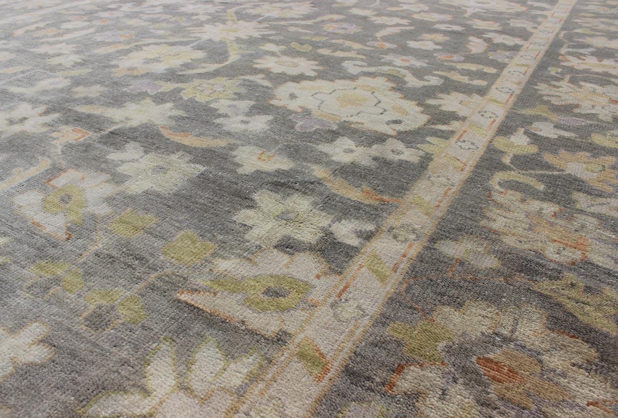 Gray Oushak With All-Over Floral Design in Green, Taupe and Orange Accents. rug OB-9393788  , Keivan Woven Arts / country of origin / type: India / Oushak, circa Early-21st Century.

Measures: 9'0 x 12'0.

Gray Oushak With All-Over Floral Design in