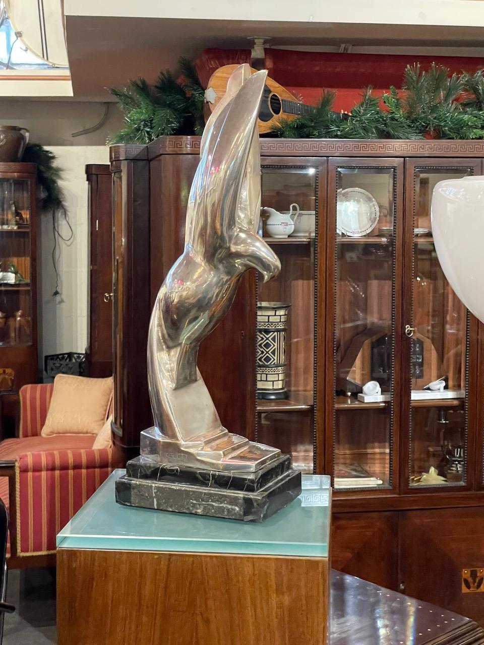 Alexandre Kéléty bronze sculpture of a stylized Eagle on marble. Powerful strong statue with a modern feeling. Soft curved lines give the feeling of flight and strength. Many obvious stepped details in the statue base, the marble base, and the way