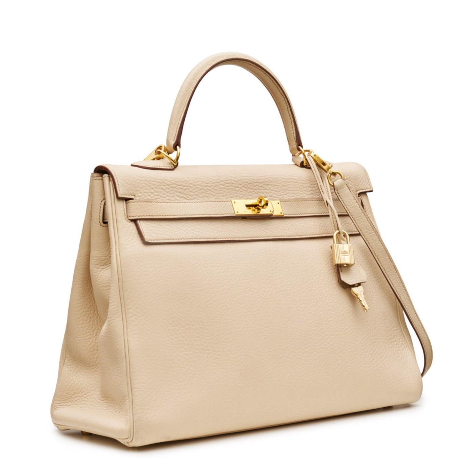 Beige
Clemence-Leder
Goldfarbene Hardware

Einfacher Griff oben
Hauptfach
Innentasche mit Reißverschluss
Aufgesetzte Innentasche

Abnehmbarer Schultergurt
Lieferung mit Vorhängeschloss, Schlüssel und Clochette
Stempel E Quadrat, Jahr 2001
Zustand: