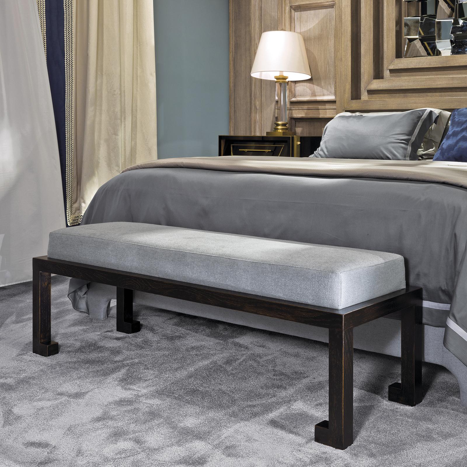 Modern and sophisticated, this bench will be an exquisite addition to a living room, entrance, or bedroom. The structure is in wood with a hand painted black finish that highlights its simple base. The rectangular cushion is upholstered with a light