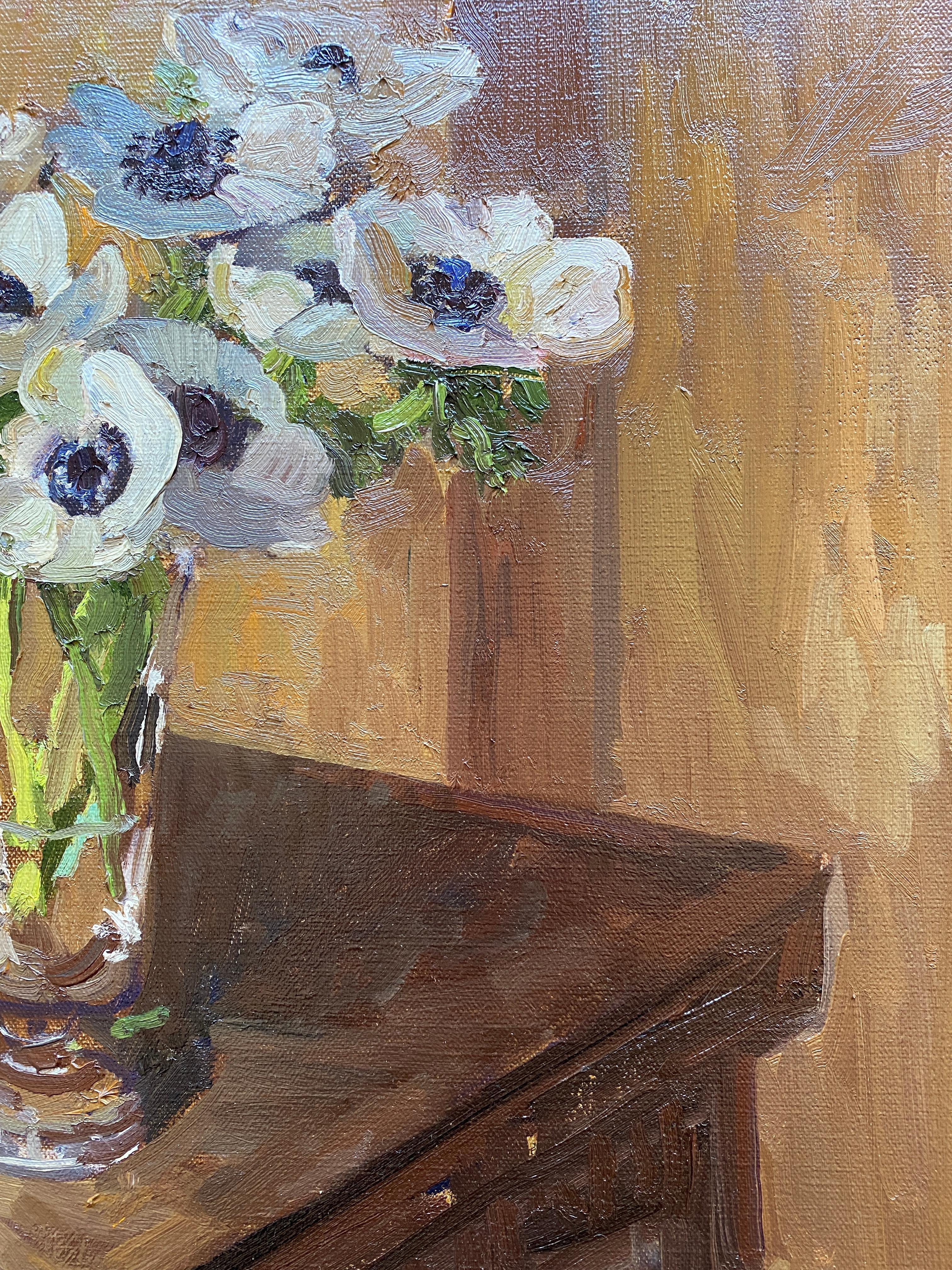 A Still life painting of white anemones in a slim glass vessel, situated on the corner of a wooden table. 

Framed in a natural brown wood floating frame.

Framed dimensions: 21 x 21 inches
Painting dimensions:20 x 20 inches

Kelly Carmody has