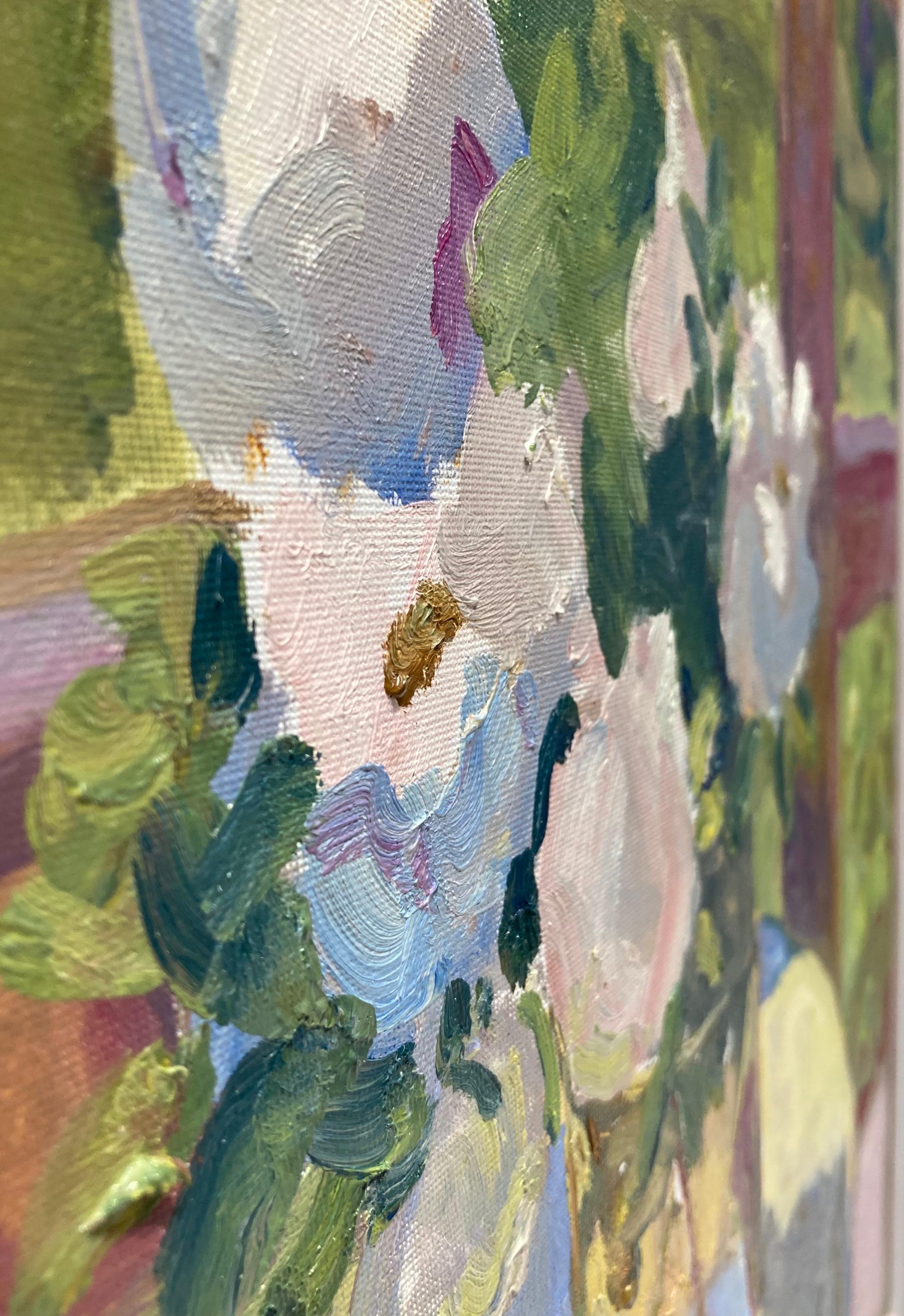 An impressionistic painting of a bouquet of roses in a reflective glass vase on a porch with a landscape in the background. Soft white and pink brushstrokes make up the roses. The light in the painting casts a dark shadow of the voluminous flowers