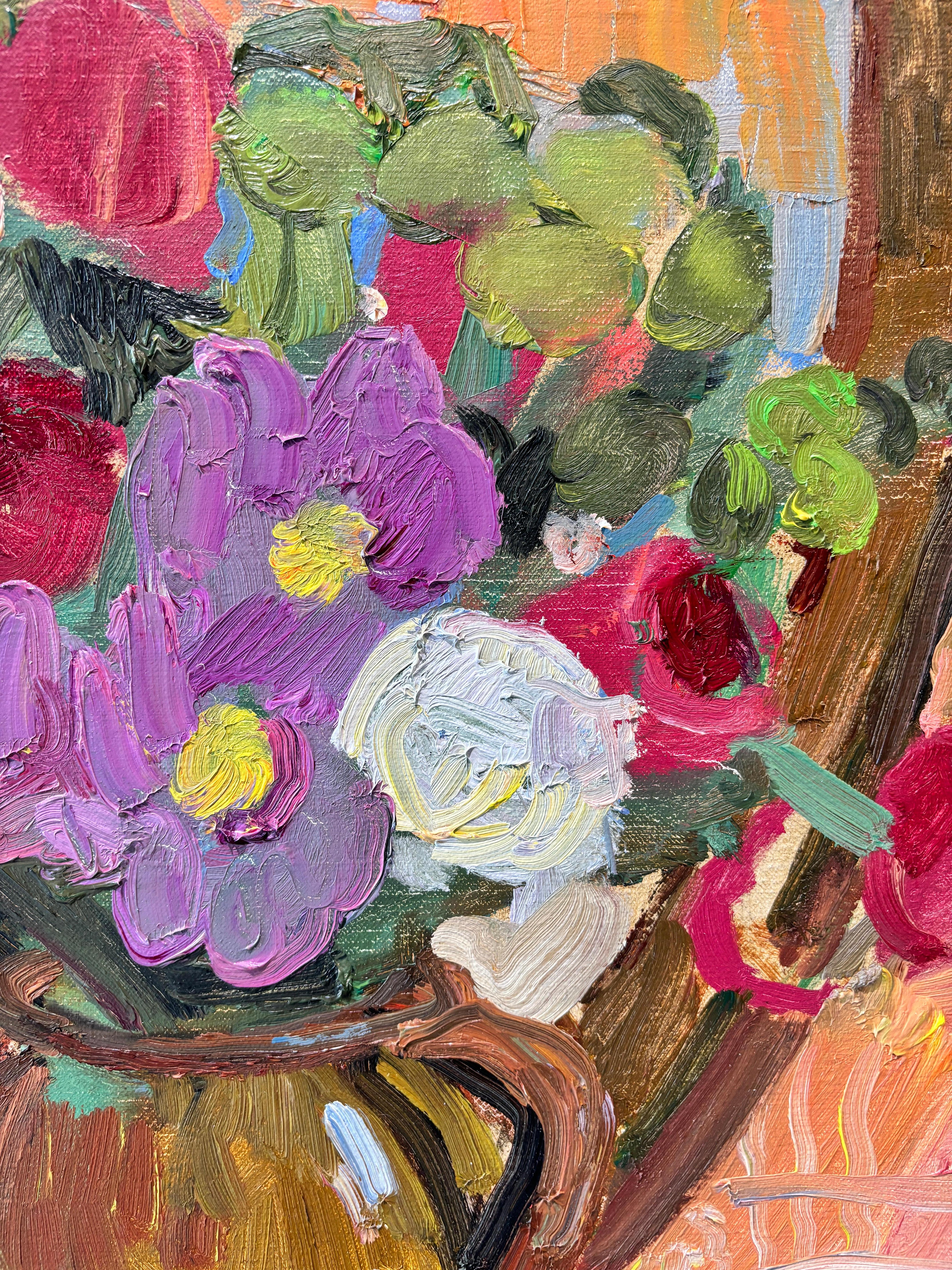Peinture à l'huile de l'artiste peintre américaine contemporaine Kelly Carmody. Un bouquet de fleurs jaillit d'une cruche en céramique à rayures bleues. Un livre épais est posé sur le plateau de la table à carreaux. Assise devant un miroir, la pièce