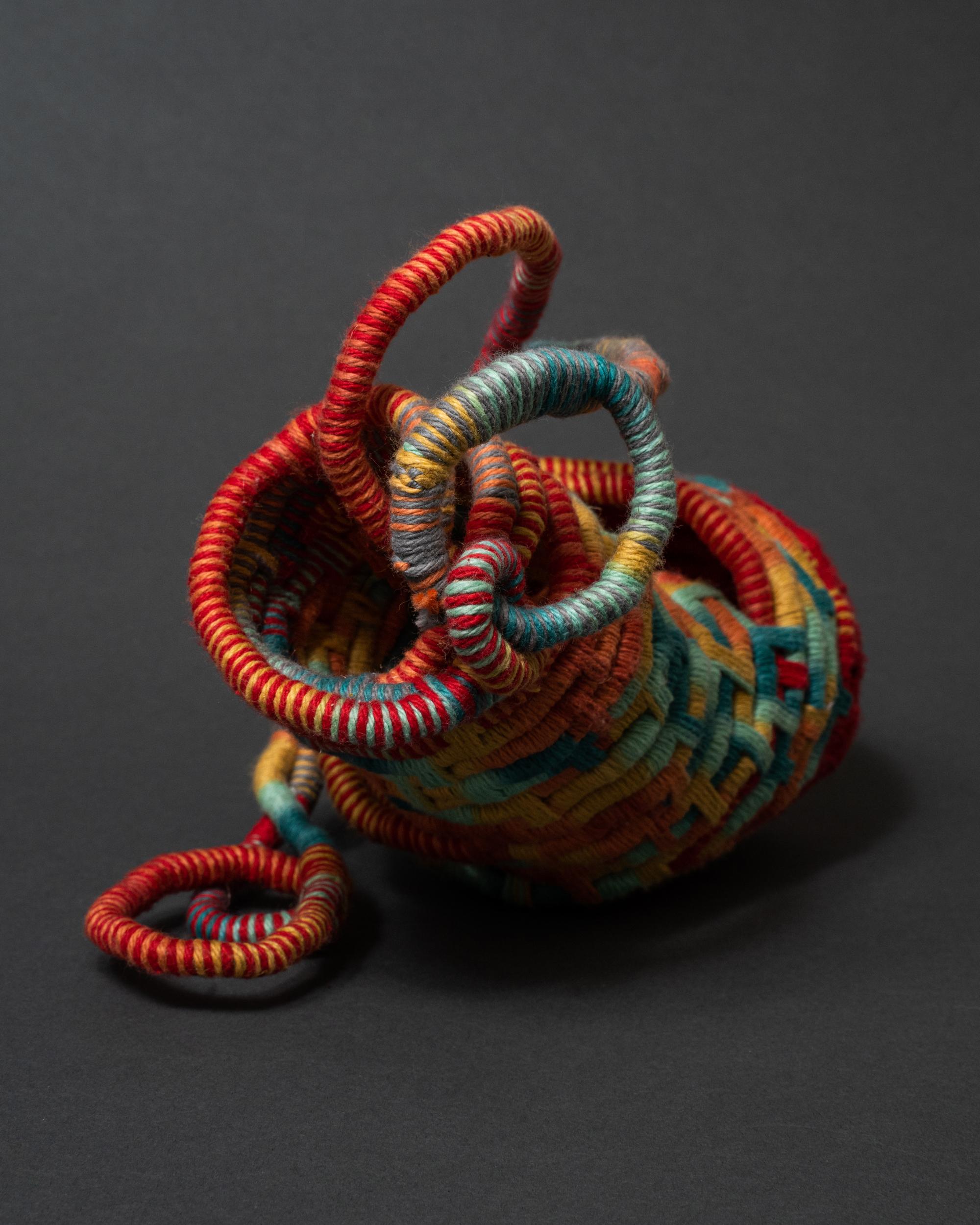 Coiling cord and cotton yarn textile sculpture.  Pink, yellow, blue, green, fuchsia, yellow, red. Fiber art, fine art basketry. 

This 