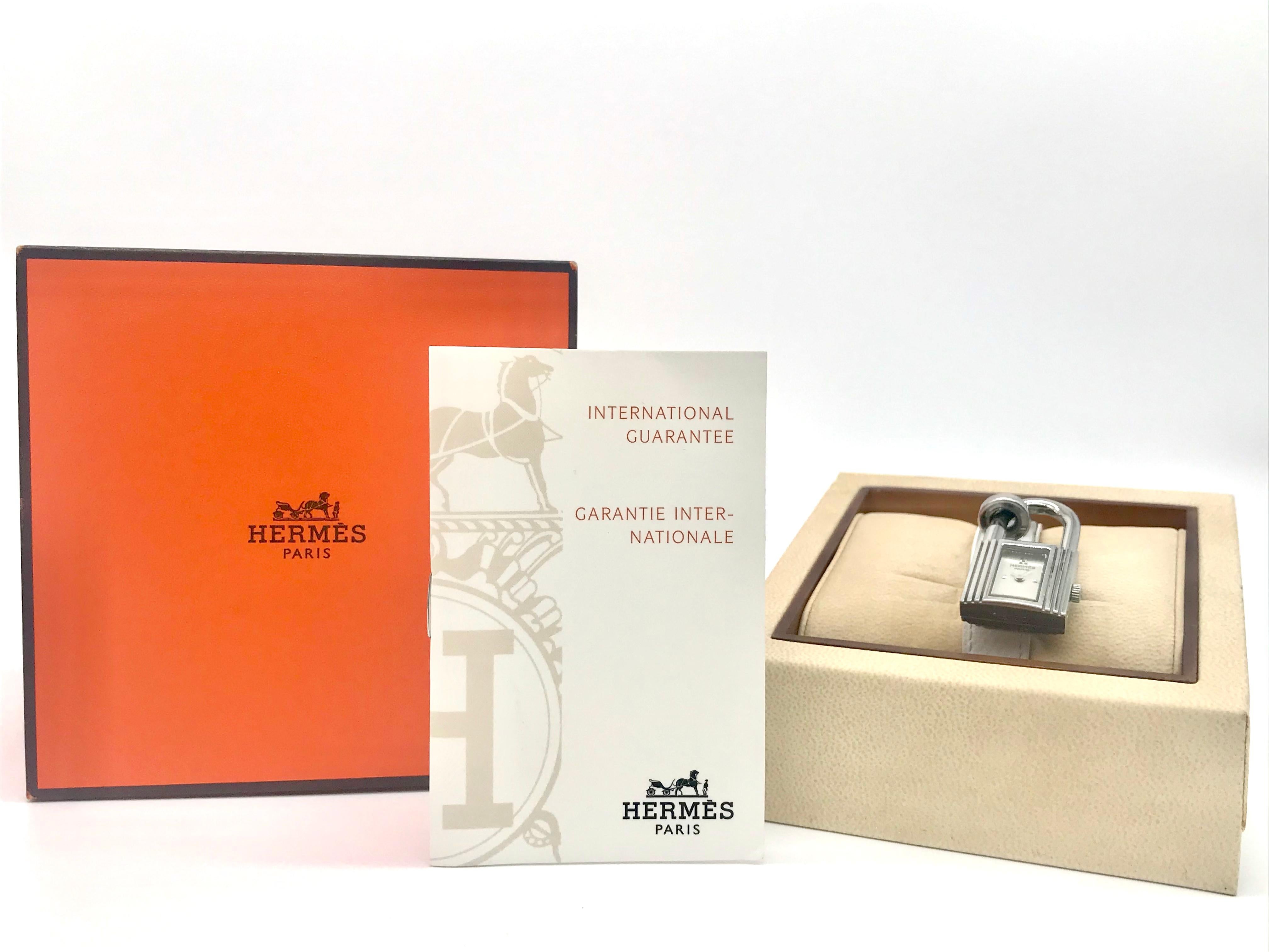 Kelly Hermes Watches
White calfskin Bracelet 
stainless steel
Dimensions of the housing 20 x20 cm 
With certificat and Original Box 
Kelly watch with padlock shape on a moblile brass ring, index 4, quartz movement, on buckle adjustable buckle