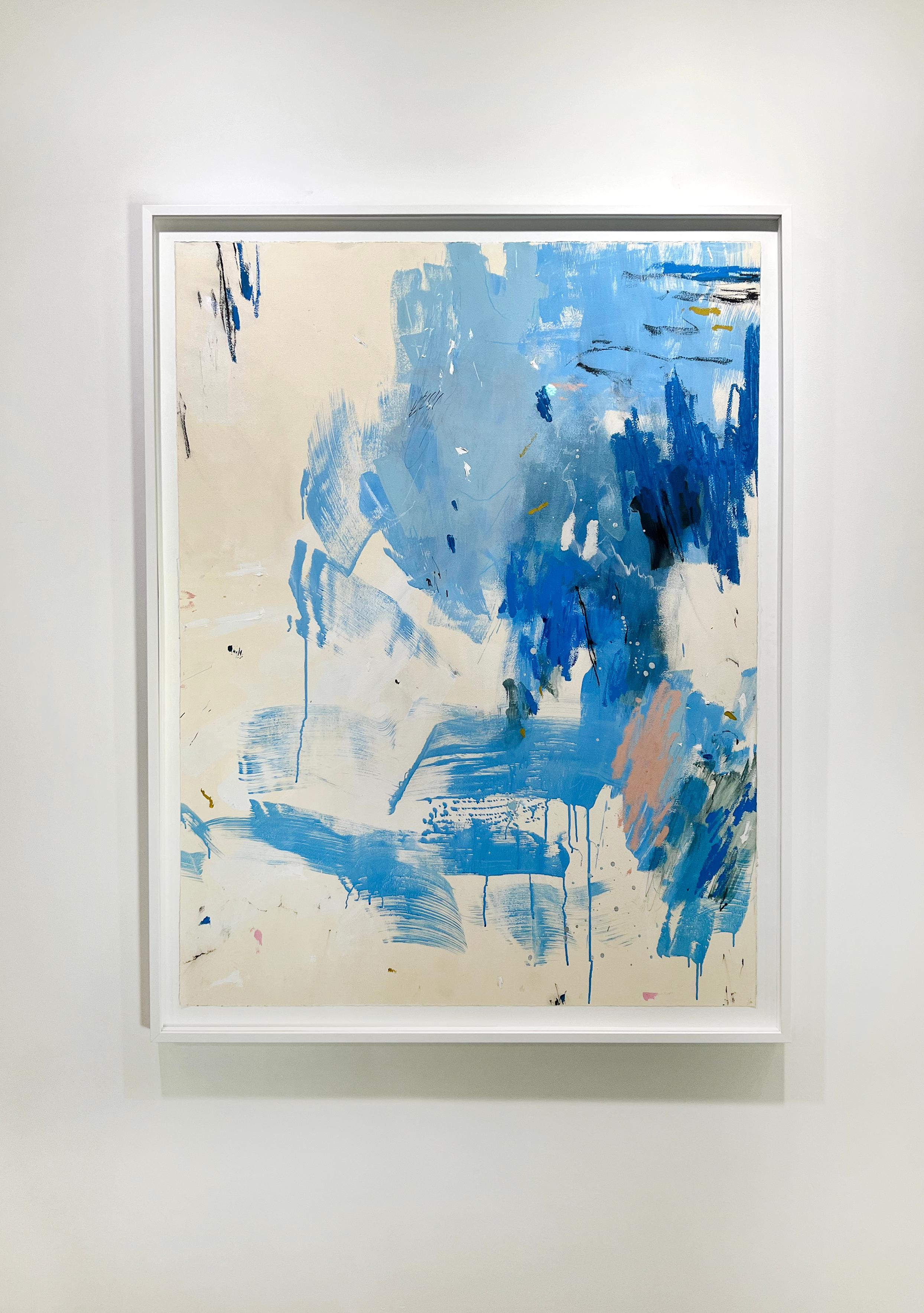 This original framed abstract painting on paper by Kelly Rossetti features a cool blue palette. Expressive strokes and drips of varying blue tones are contrasted by smaller warm dabs of paint as well as an off-white background. The painting itself