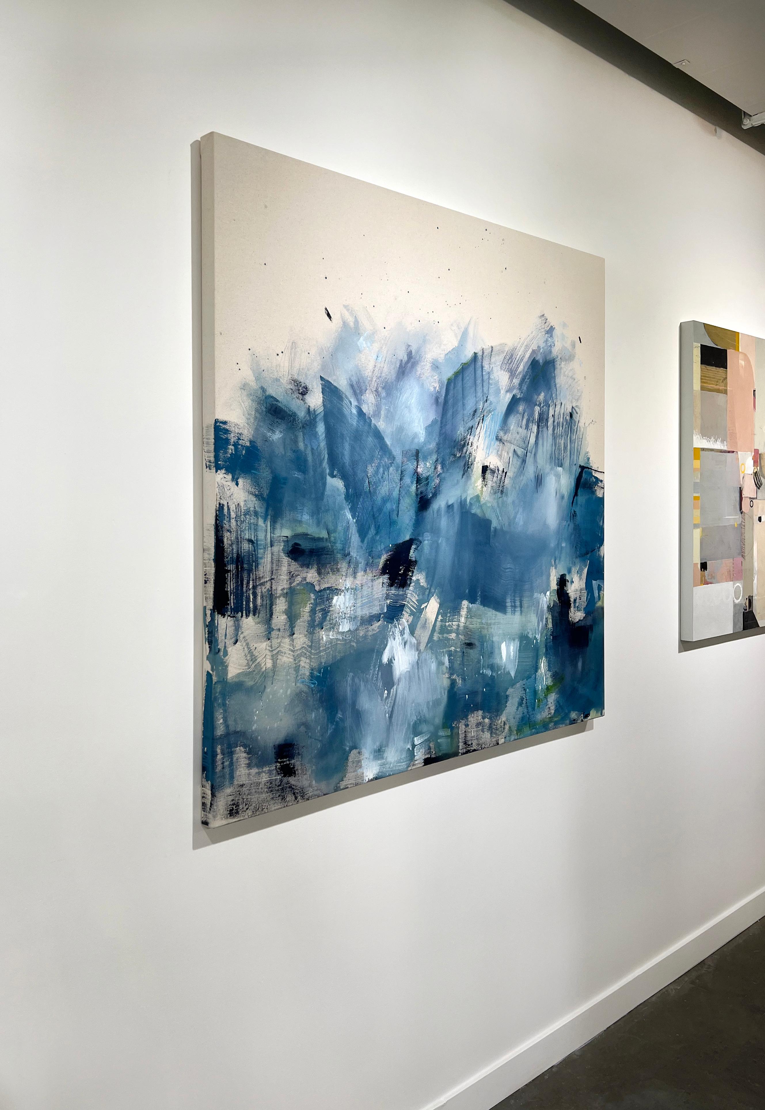 This abstract statement painting by Kelly Rossetti features a cool palette. Tones of muted blue are layered and washed together in large, expressive strokes, with accents of black, white, and green. The color extends from the bottom of the painting