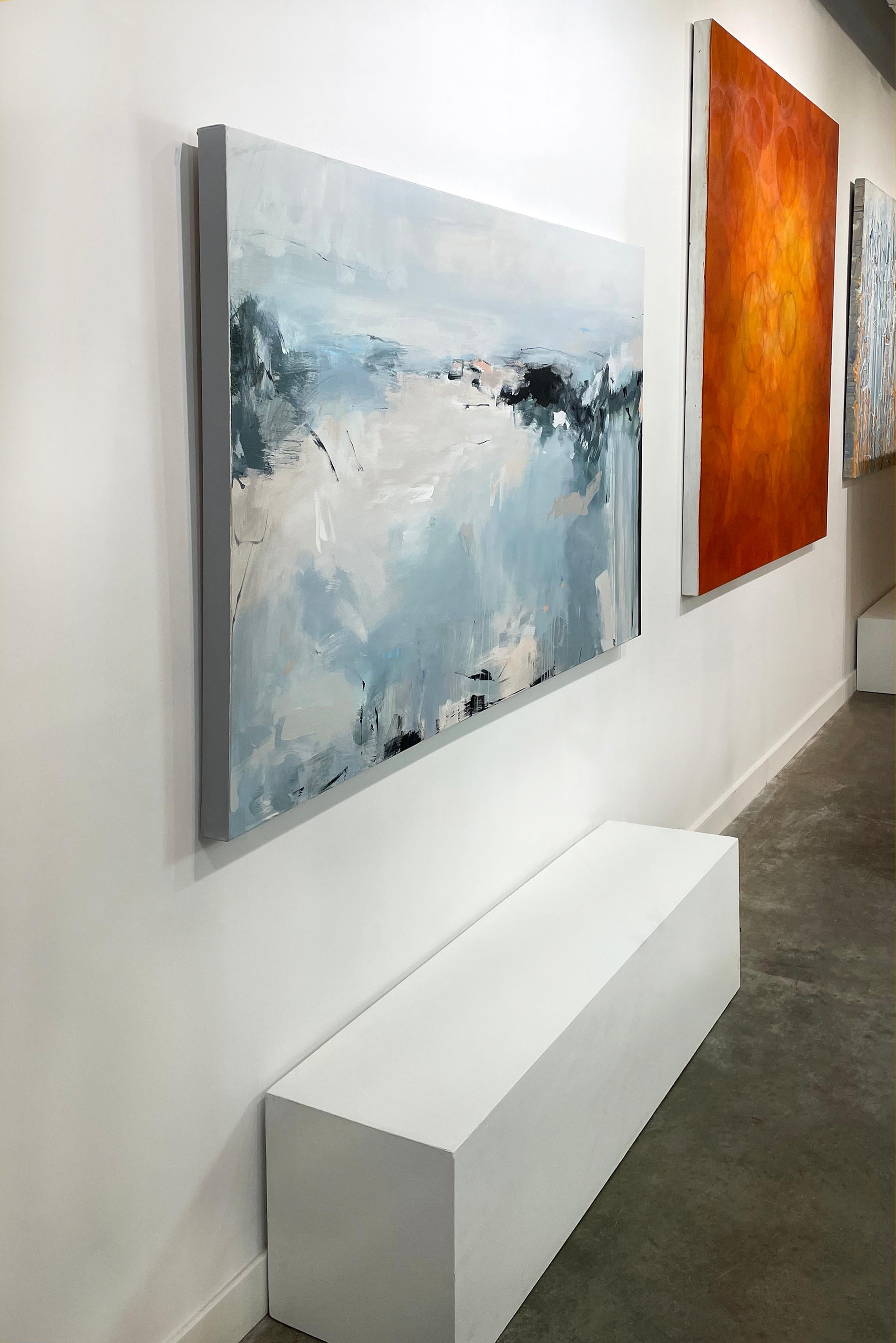 This contemporary abstract painting by Kelly Rossetti is made with acrylic paint on canvas. It features a cool palette, with light blue, grey, white, charcoal black accents and contrasting pale pink added in broad, energetic strokes throughout. The