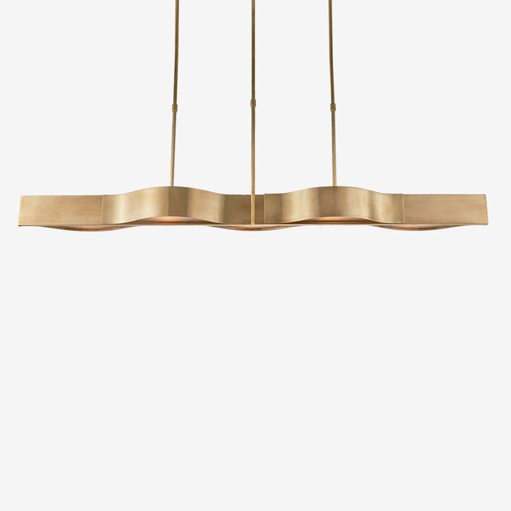 The Avant linear pendant emanates a simplistic modernism inspired by the pure interaction between line and curve. This linear pendant is available in antique brass, bronze or polished nickel with frosted glass and is rated for use in damp
