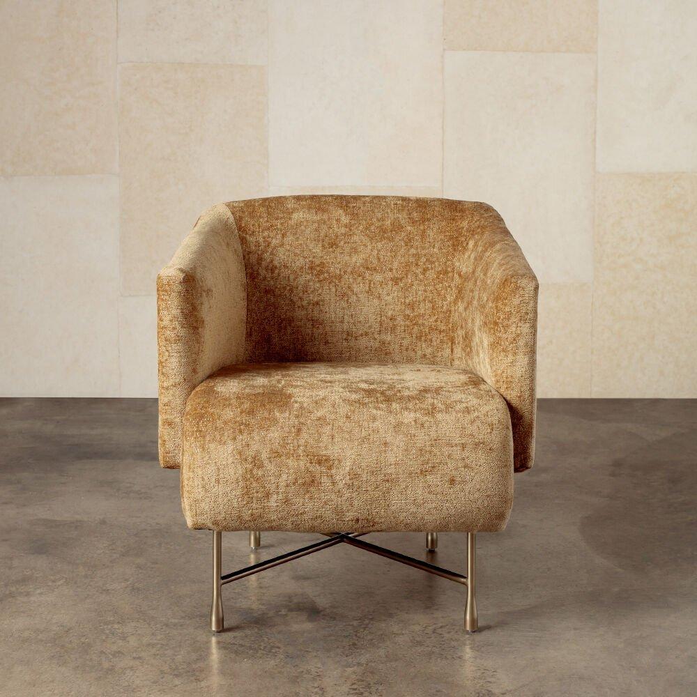 The bijoux chair, features a tight upholstered seat and back, with an upright but comfortable seating position, married to a lustrous and architectural burnished brass base. The thin back and upward sweeping shelter style arms along with the soft
