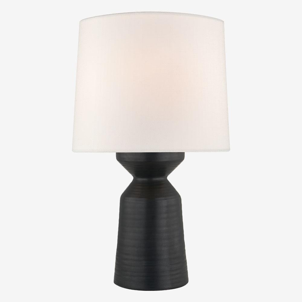 With its sculptural quality, the Nero large table lamp exudes a versatile style that is both artisanal and modern. This table lamp features a ceramic base with either a Matte Black or Matte White finish paired with a Linen shade.

International