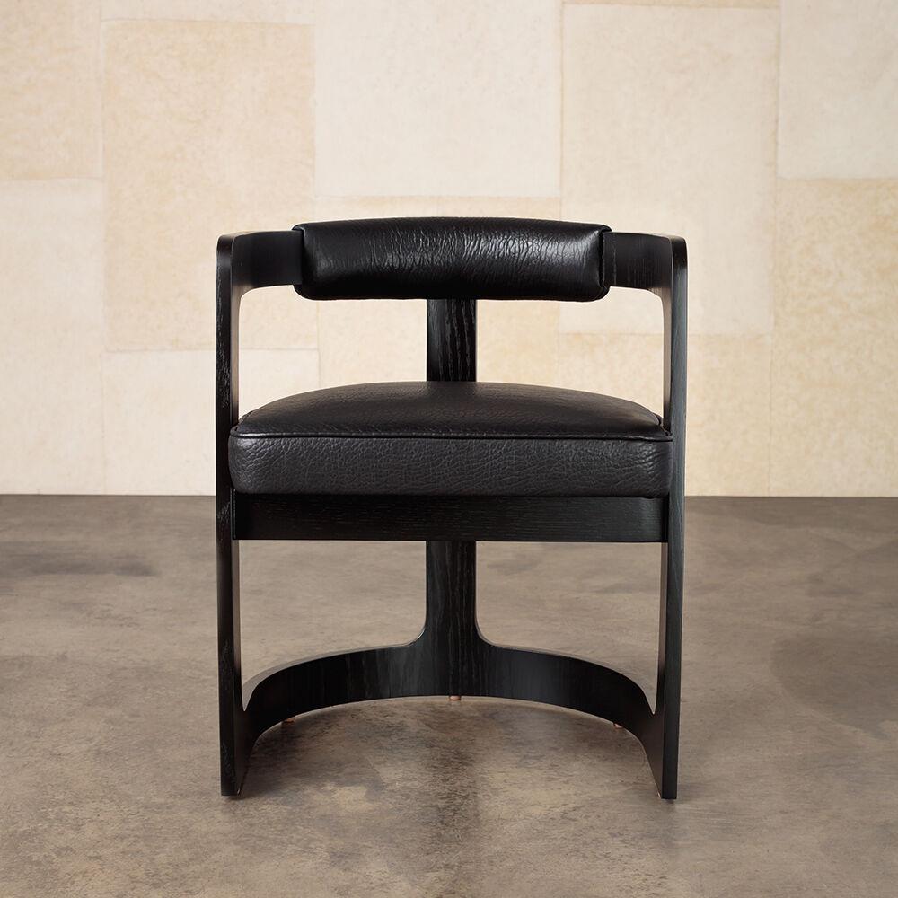The clean, architectural lines and casual sensibility of the Zuma dining chair make this dining option a modern Classic. The bent oak frame with its sweeping curves comes in an ebonized or bleached finish with thoughtful brass detailing. The tightly