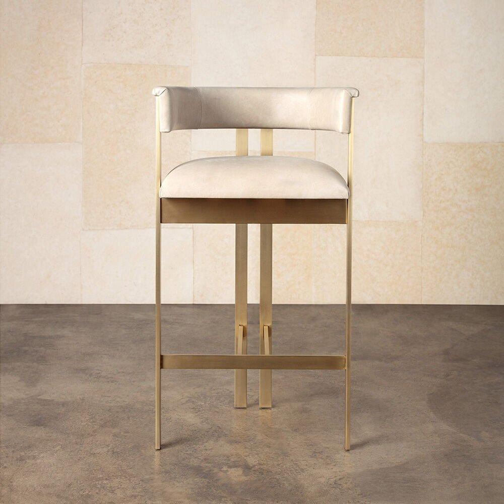 A truly timeless form with modern proportions, the Elliott bar stool is crafted in leather and solid brass, giving it substantial weight. With a curved back, gathered rear legs and a signature mix of materials, the stool is beautiful from all