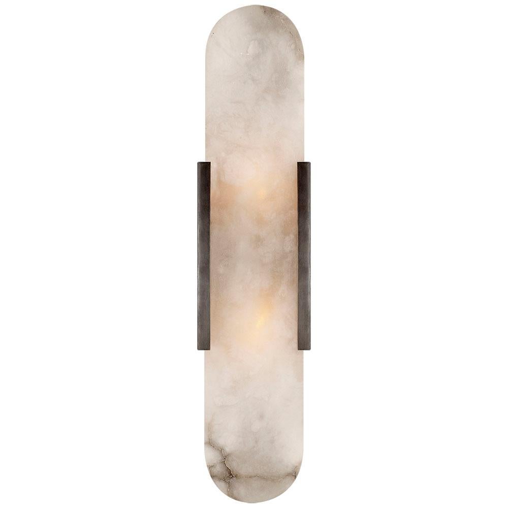Effortlessly pairing natural alabaster and sleek metal detailing in a streamlined geometric form, the Melange elongated sconce exudes a modern refinement while emphasizing the beauty of natural stone. This sconce features hand-carved natural