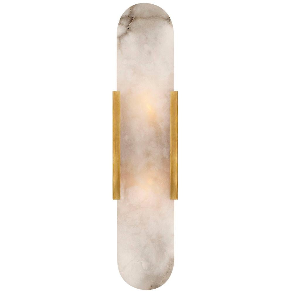 Effortlessly pairing natural alabaster and sleek metal detailing in a streamlined geometric form, the Melange elongated sconce exudes a modern refinement while emphasizing the beauty of natural stone. This sconce features hand-carved natural