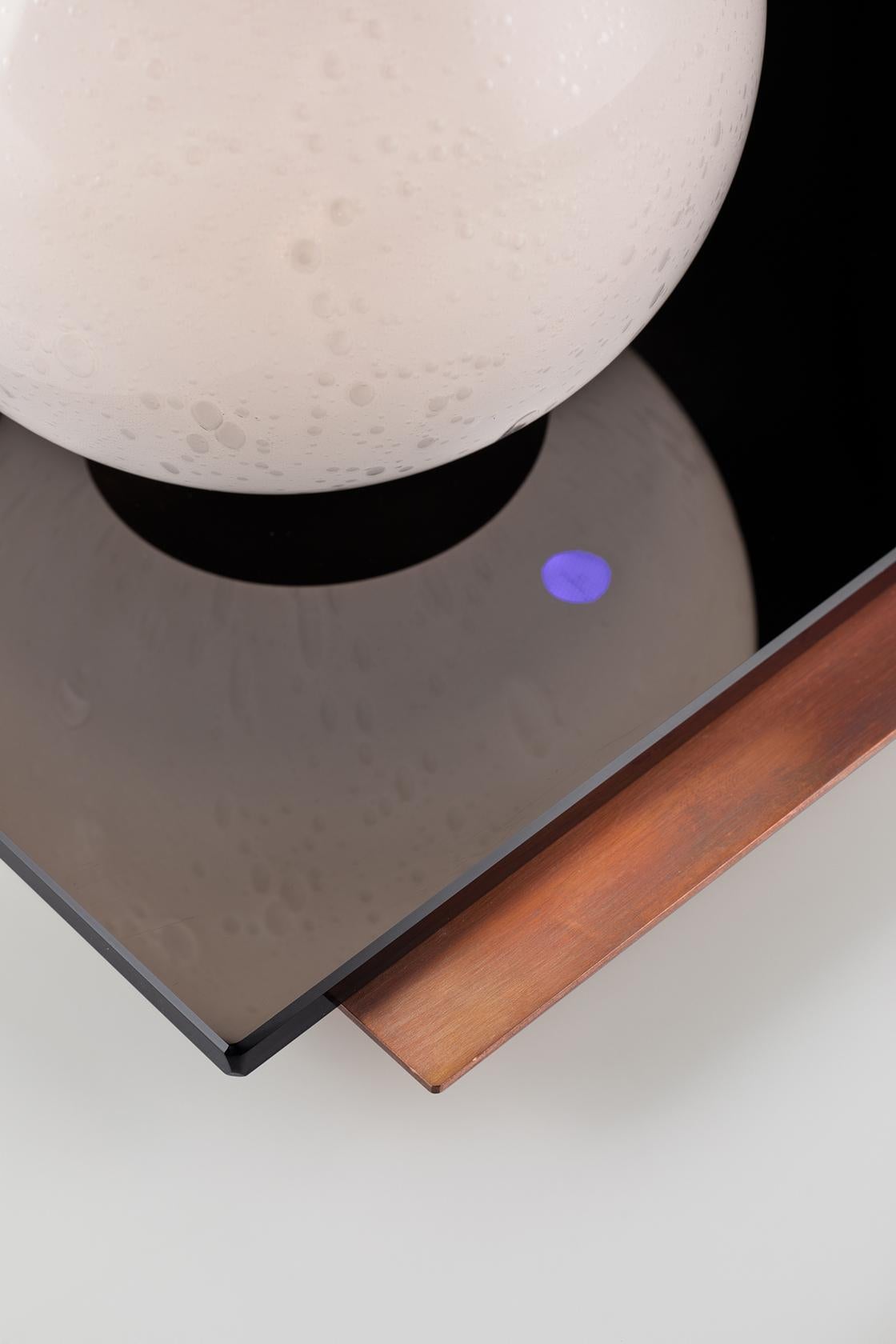 Tischleuchte mit Soft-Touch-Dimmer-LED-Technologie in Kupfer und schwarzem Spiegel, mit einem kugelförmigen Leuchtkörper aus geblasenem Glas. Kelmo ist inspiriert von dem Konzept des 