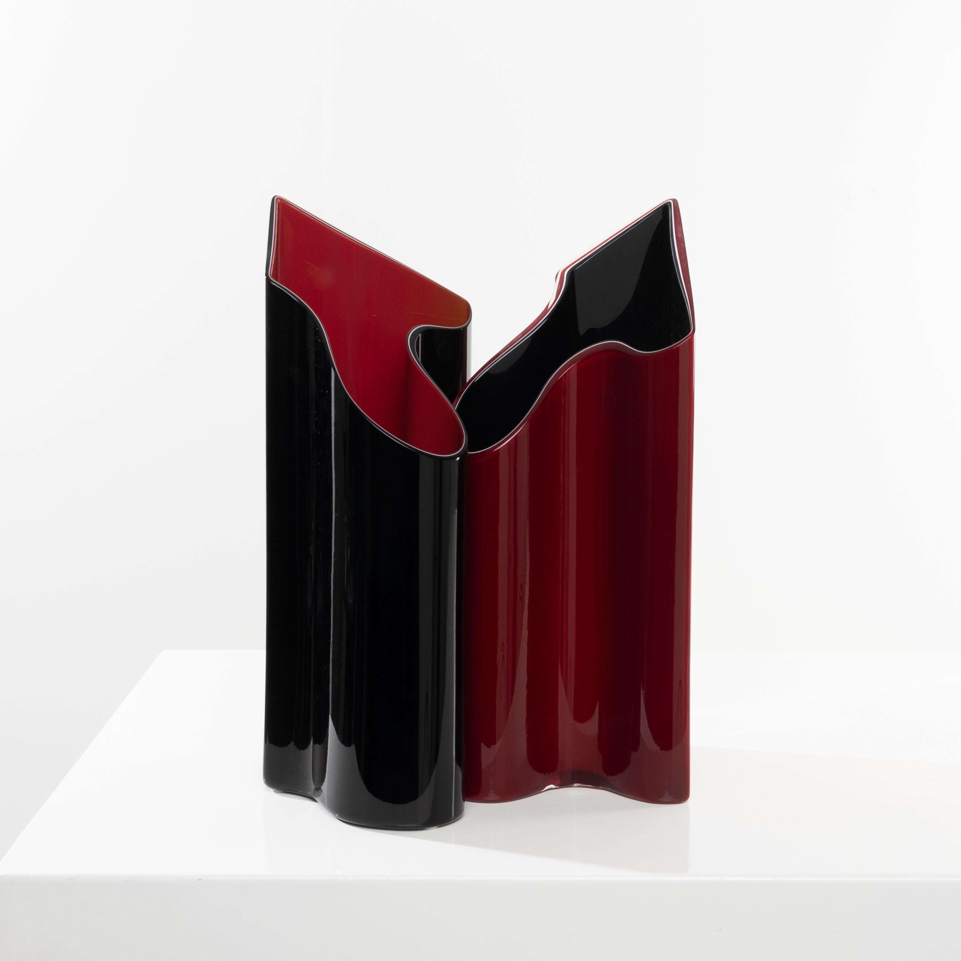Pair of vases with inverted colors.
For the first vase: The exterior is bright red and the interior is deep black. Between these two layers, there is a thin line of white glass, which gives depth to the two main shades.
For the second vase: The