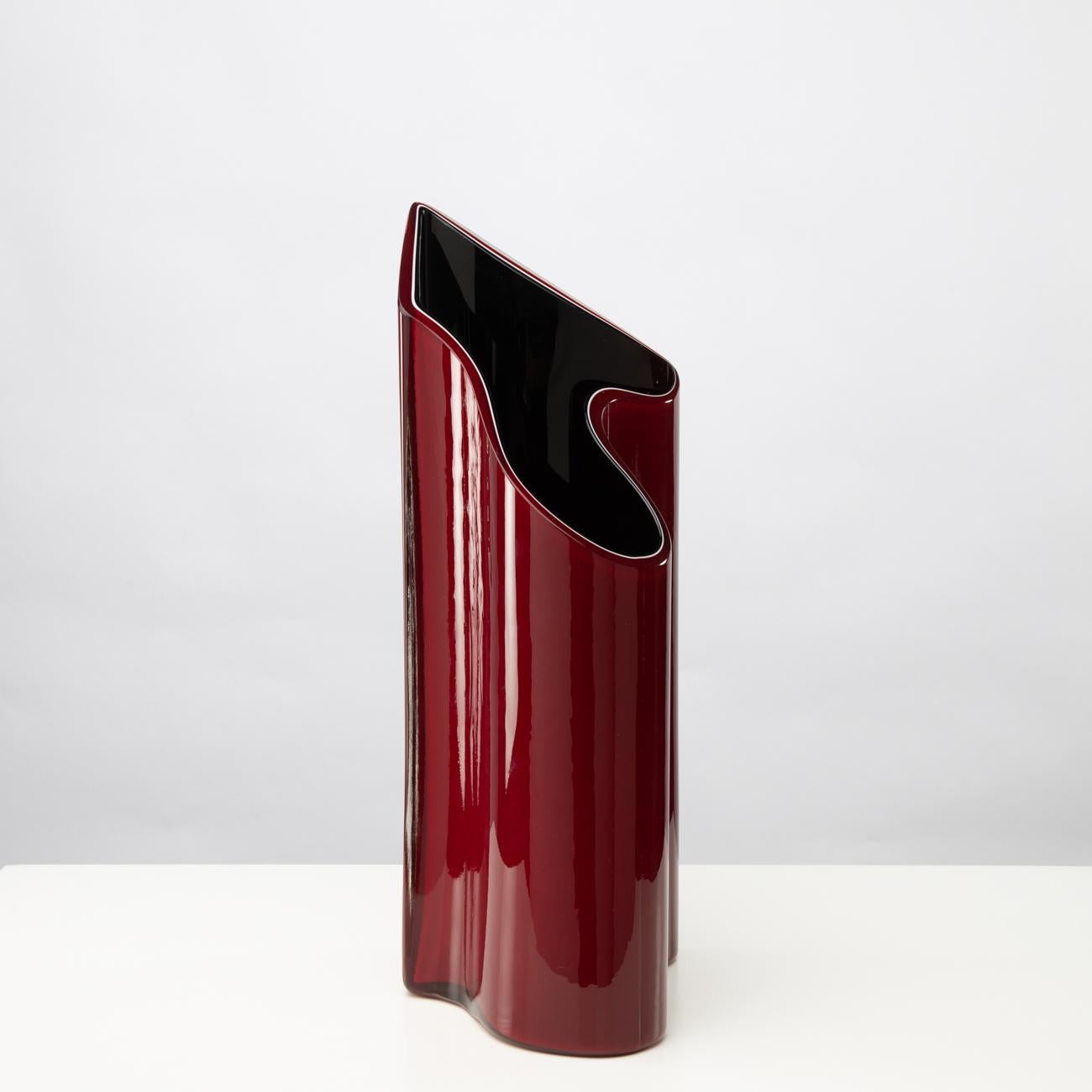 A large and spectacular vase with a typical 90s design and a very unusual shape, between these two layers, the black and the red, is a thin line of white glass, which gives depth to the vase.  
 
Timo Sarpaneva was invited by Paolo Venini to join