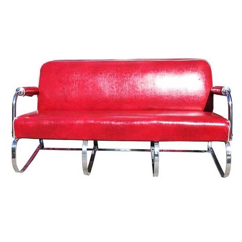A Kem Weber designed chrome flat iron sofa, featuring a bent spring-like base with the iconic rolled Weber arms. The arms are topped with red padded vinyl armrests that follow the curvature of the Sofa's design. This is a great example of 1930s