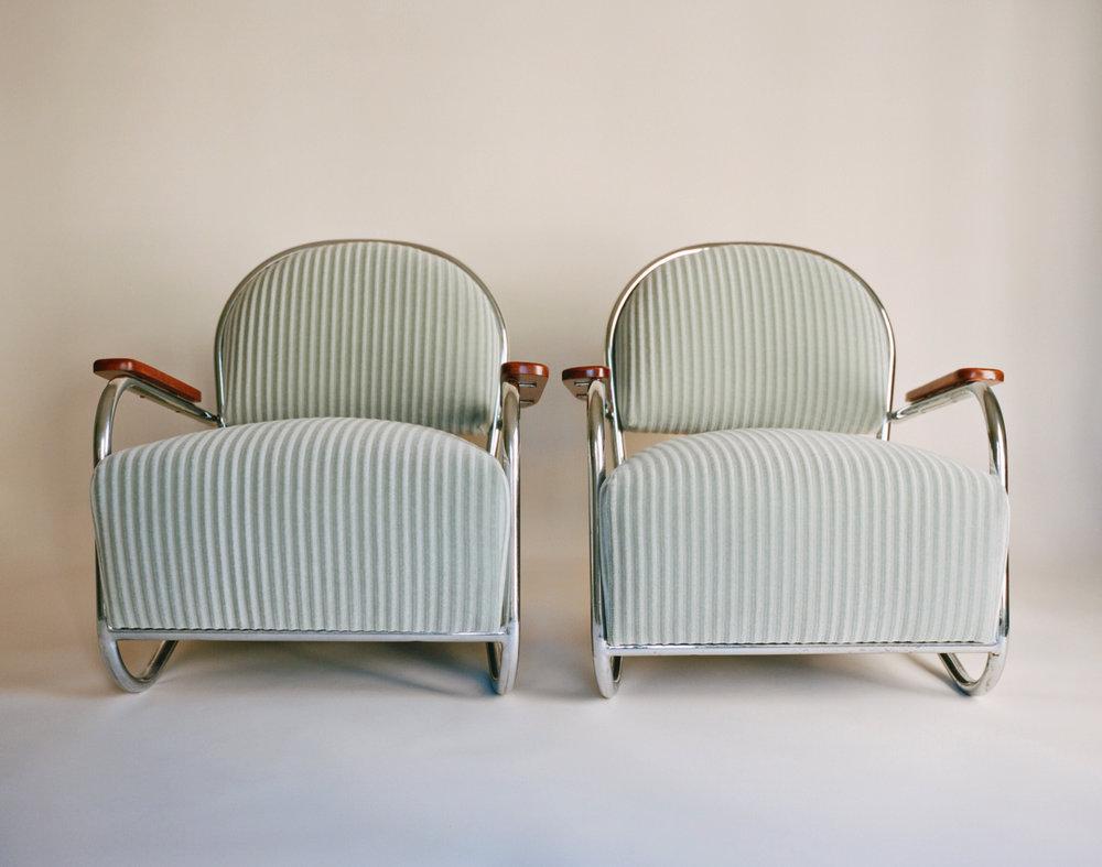 A pair of chromium-plated tubular steel lounge chairs upholstered in thick, sage green corduroy with lacquered walnut armrests. Weber designed these chairs in 1934 for the Lloyd Manufacturing Company in Menominee, Michigan. These chairs debuted at