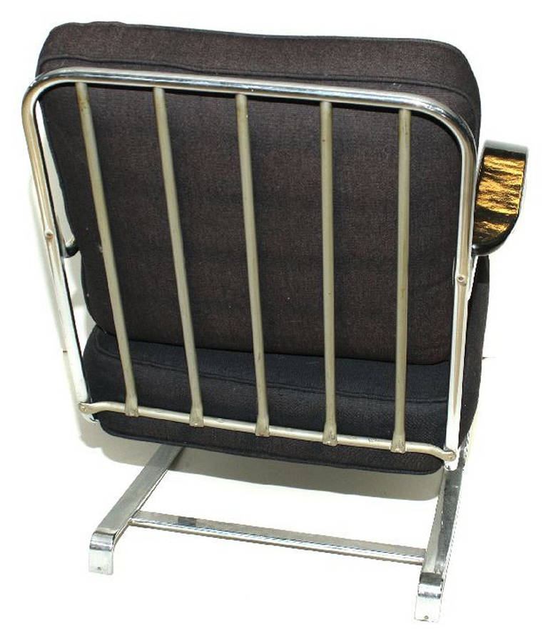 Known as the “Springer” chair, the chairs sit on flat band chrome iron springs and function as rocking chairs.
 
The chair retains its original chrome and with newly made cushions.
 
The black arms have been polished to a high gloss lacquer-like