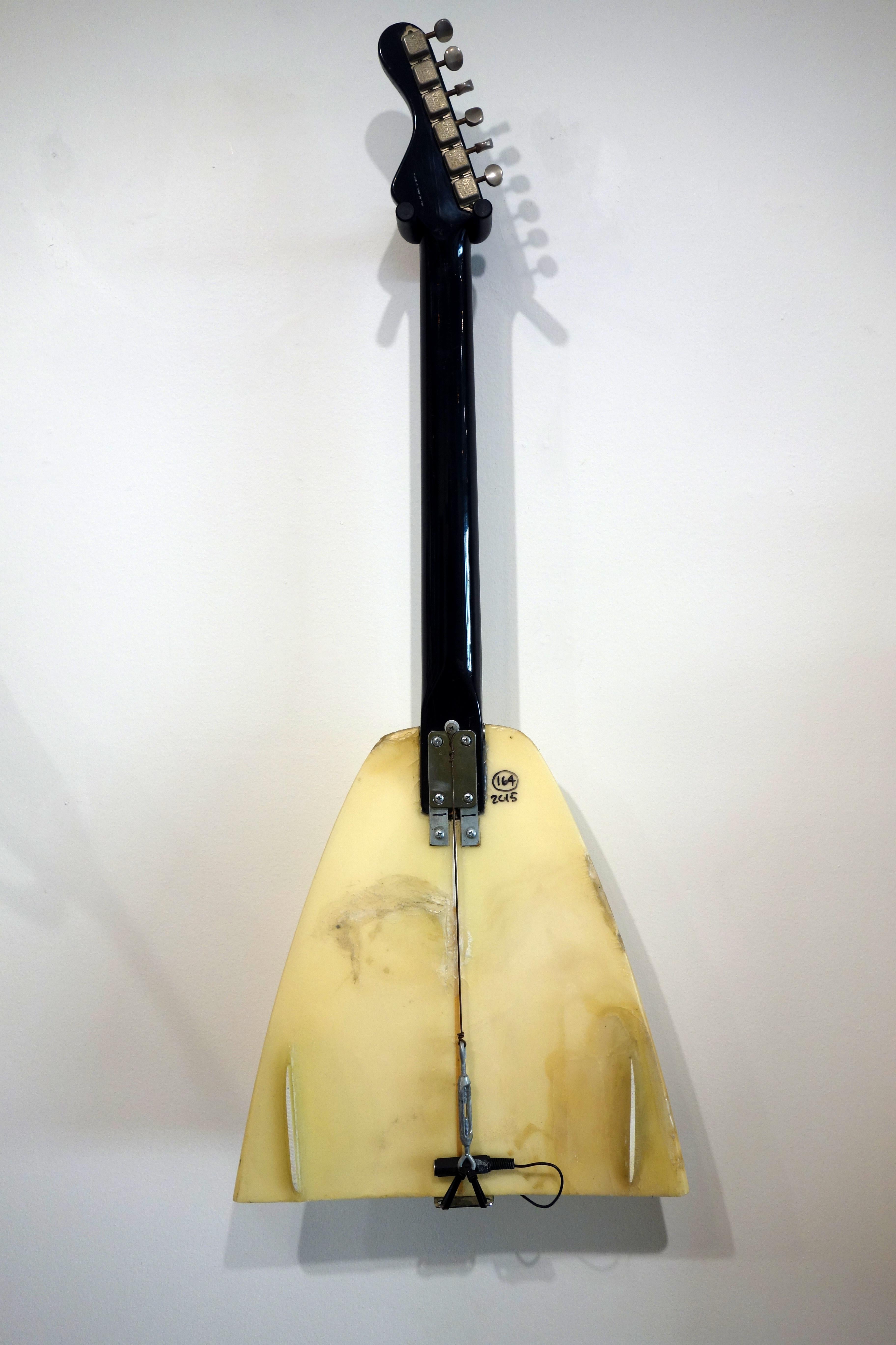 Cette sculpture créée par Ken Butler est à la fois une guitare et une planche de surf. Elle est réalisée dans l'esprit d'absurdité que de nombreux surréalistes ont adopté en utilisant des objets trouvés dans des scénarios fonctionnels. signé par