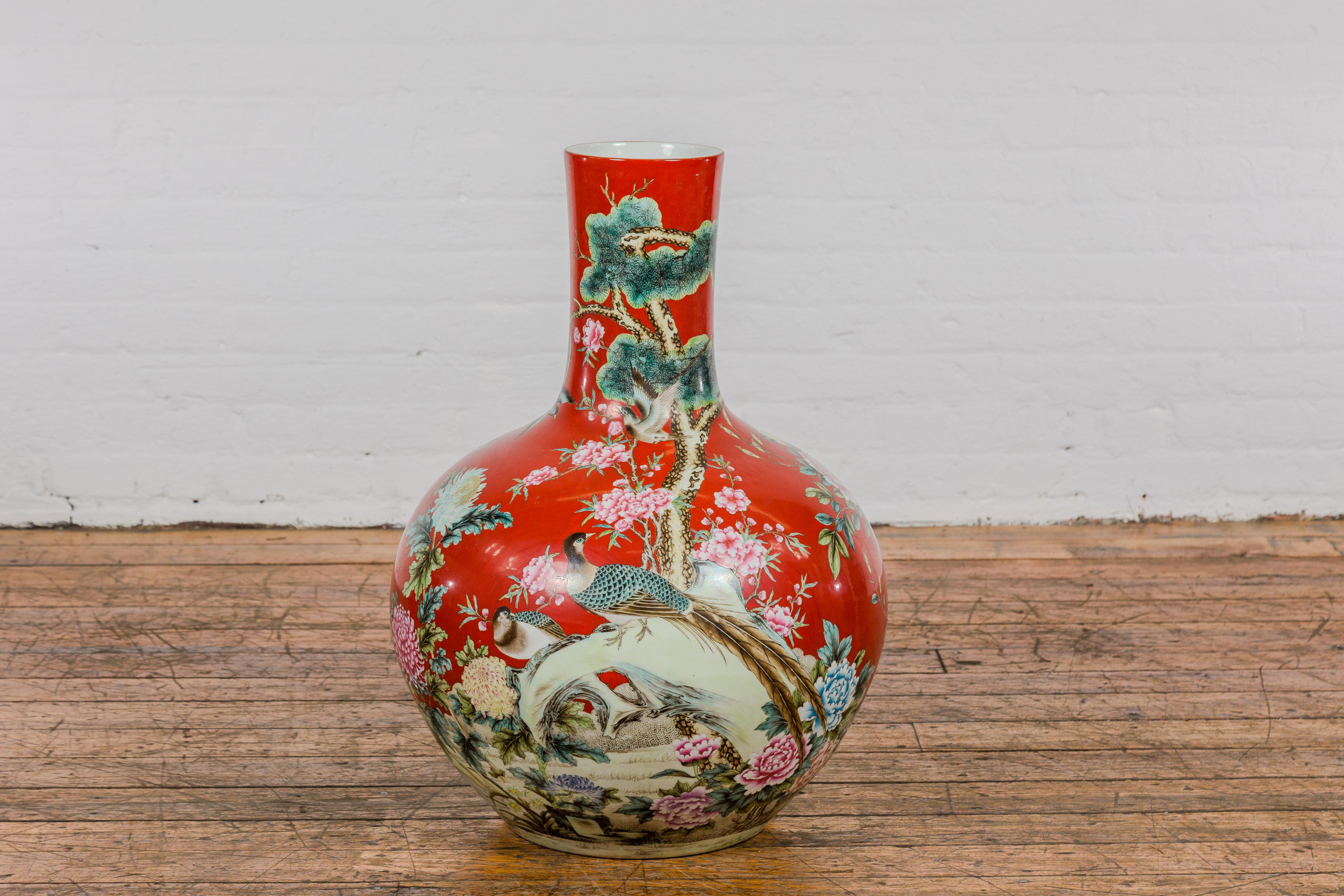 A Kendi style red porcelain vase hand painted with bird and floral patterns from mid century China. Discover the beauty of the Orient with this captivating Kendi-style red porcelain vase, meticulously hand-painted with delicate bird and floral