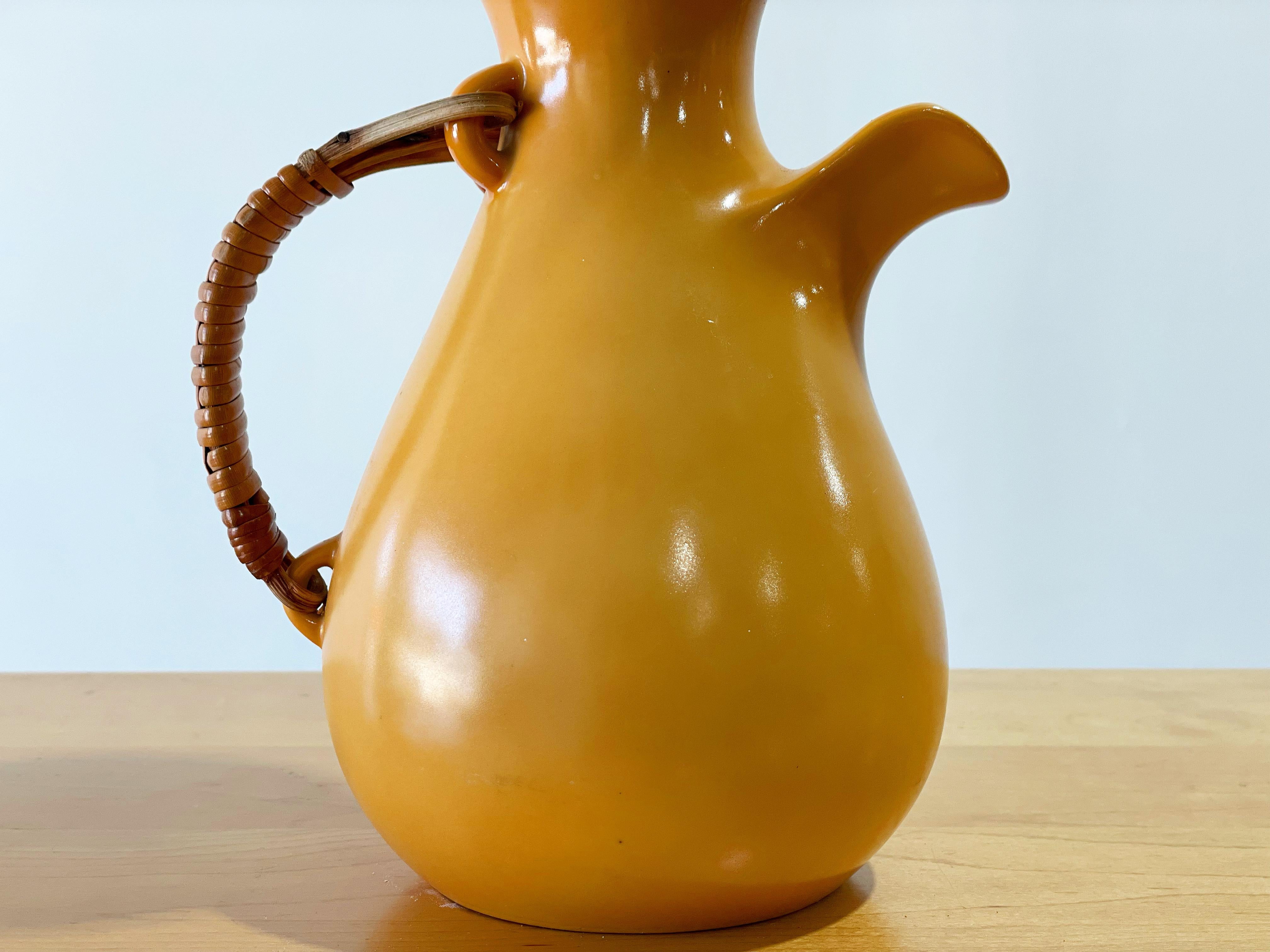 Exquisite modernist coffee carafe designed by Kenji Fujita for Freeman Lederman. Beverage pitcher in rare apricot glaze with glossy white interior. Marked with the FL logo. This example in the 