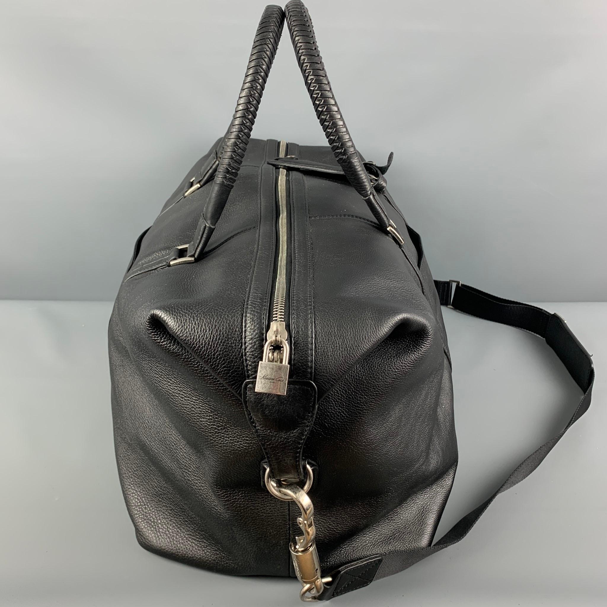 KENNETH COLE bag comes in a black leather featuring a duffle style, top handles, detachable strap, silver tone hardware, and a top zipper closure. 

Good Pre-Owned Condition. Light wear. As-Is.

Measurements:

Length: 20 in.
Width: 9.5 in.
Height: