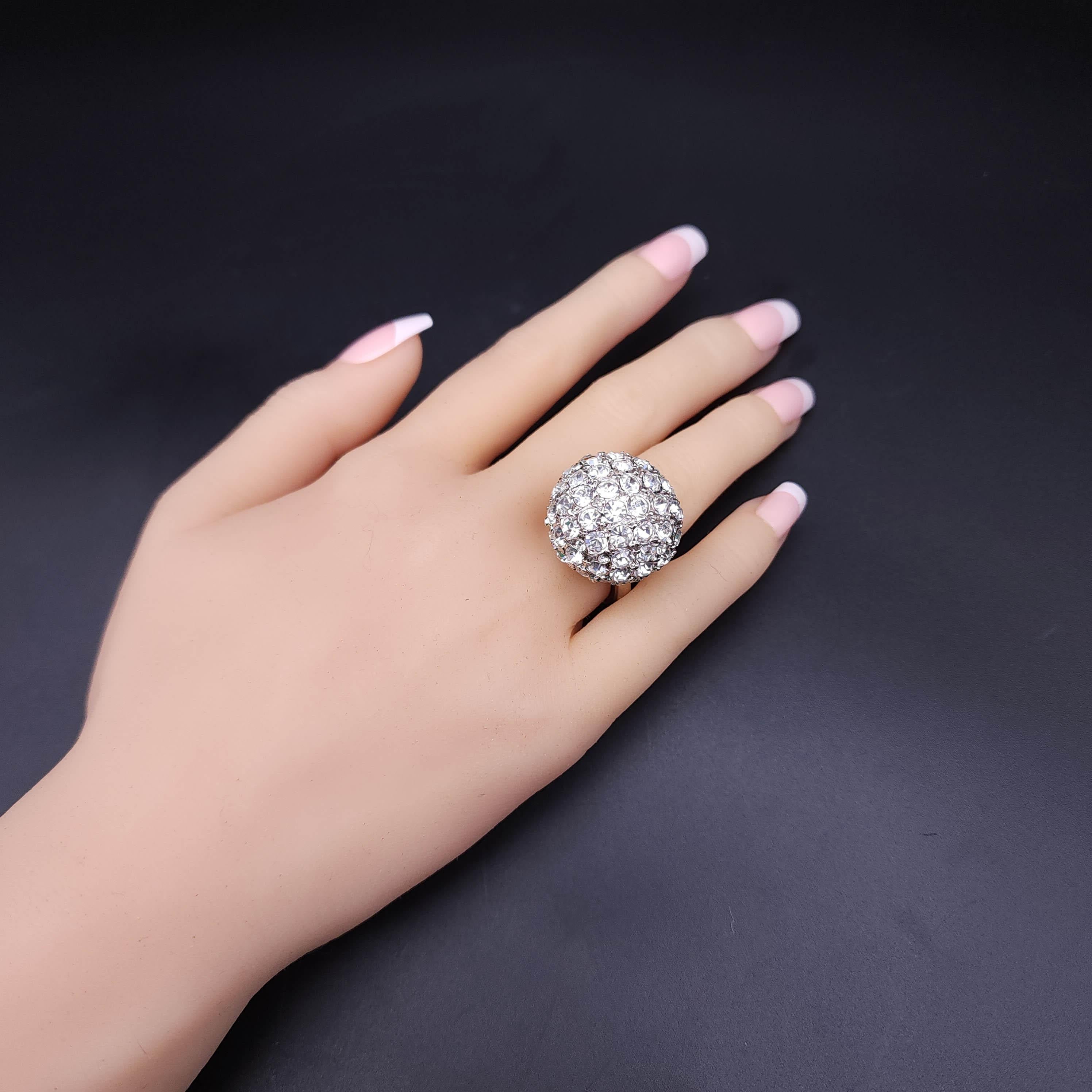 Elevate your evening attire with the Kenneth J Lane Disco Ball cocktail ring. This exquisite piece features a dazzling display of pave-set crystals that catch the light from every angle, reminiscent of a shimmering disco ball. Crafted in a sleek