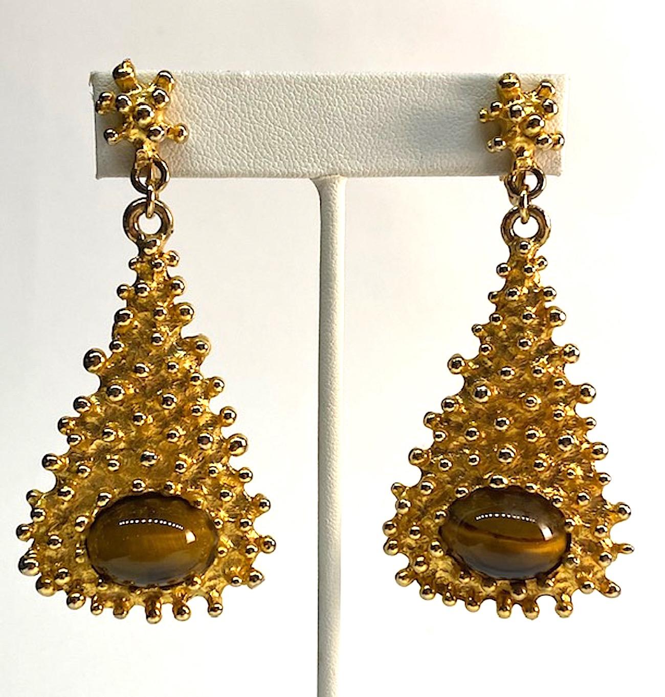 Gold nugget bead texture Kenneth Jay Lane earrings made in the mid to later 1970s. Gold tone with natural 13 x 17 mm tiger eye cabochons. Each earring is 1.5 inches wide and 3 inches long. Oval signature plaque on the back of each pendant inscribed