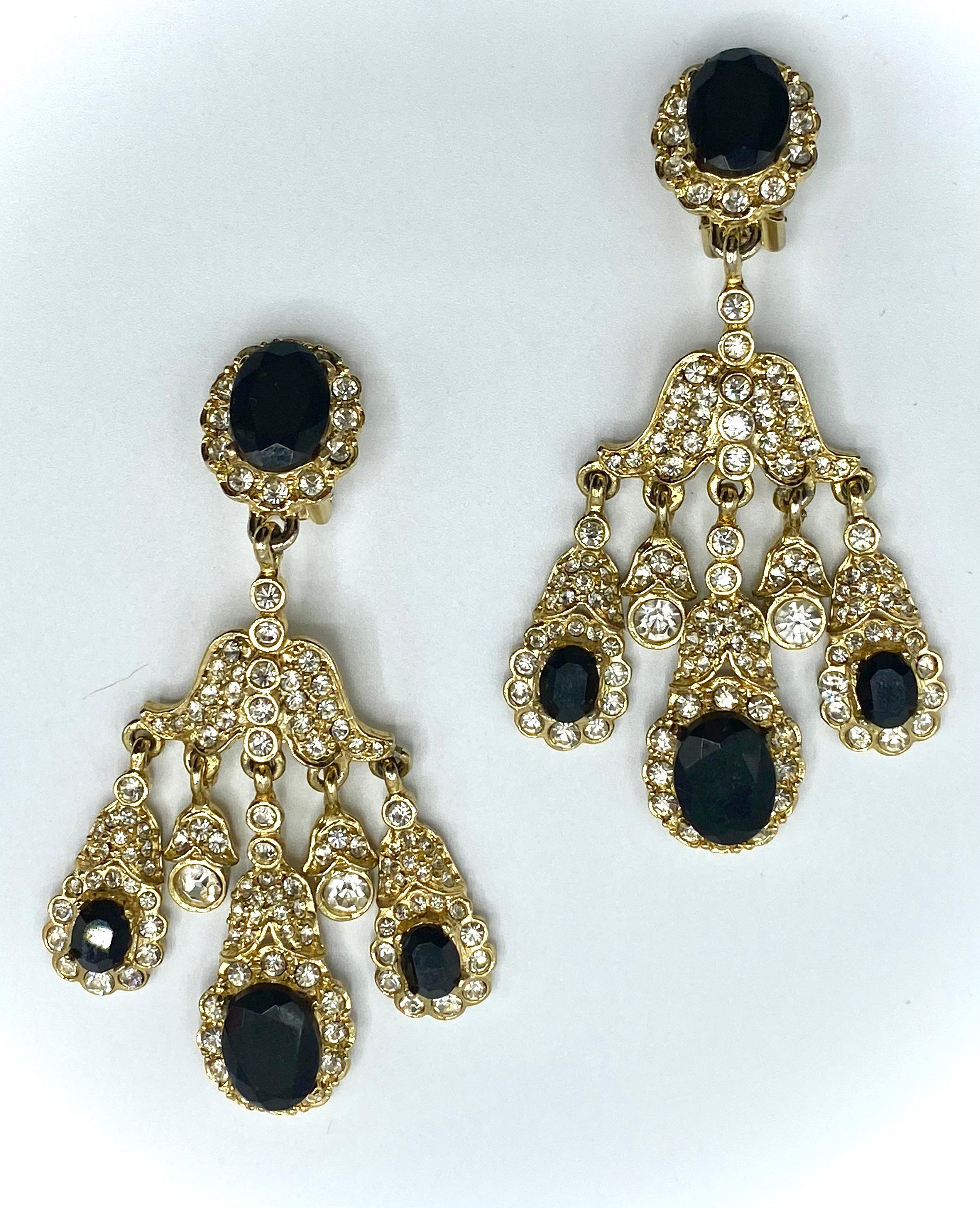 An elegant pair of 1980s Kenneth Jay Lane Girandole chandelier earrings in gold, rhinestone and black crystal. Girandole earrings have a central piece from which three pendants hang and date back to the 17th century when they first appeared. Each
