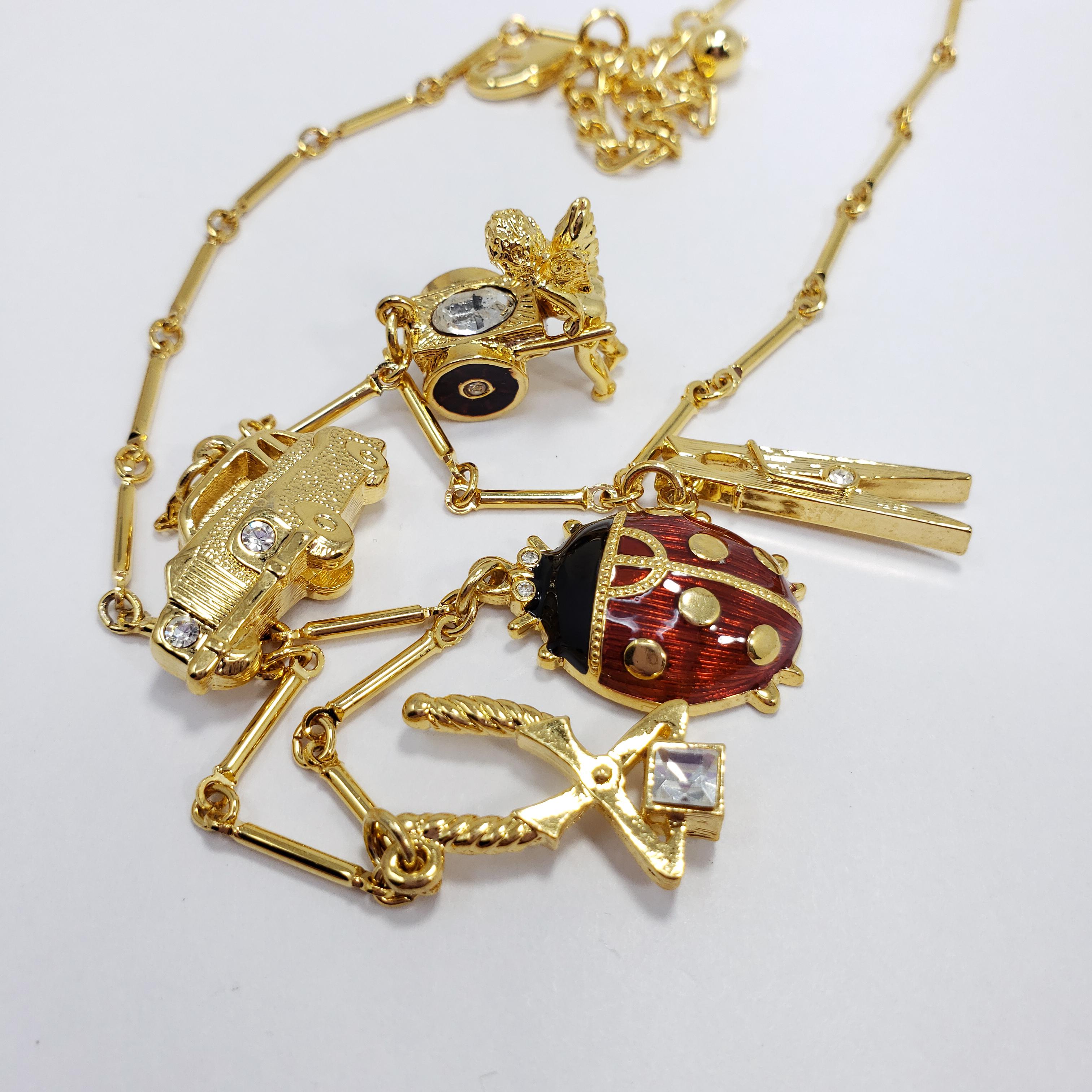A quirky necklace by Kenneth Jay Lane. Features five charms - including a ladybug, a car, an angel, and pliers. Motifs are decorated with subtle crystal and enamel accents. 

Hallmarks: Kenneth © Lane
43.5cm plus 7.5cm extension chain
Largest motif
