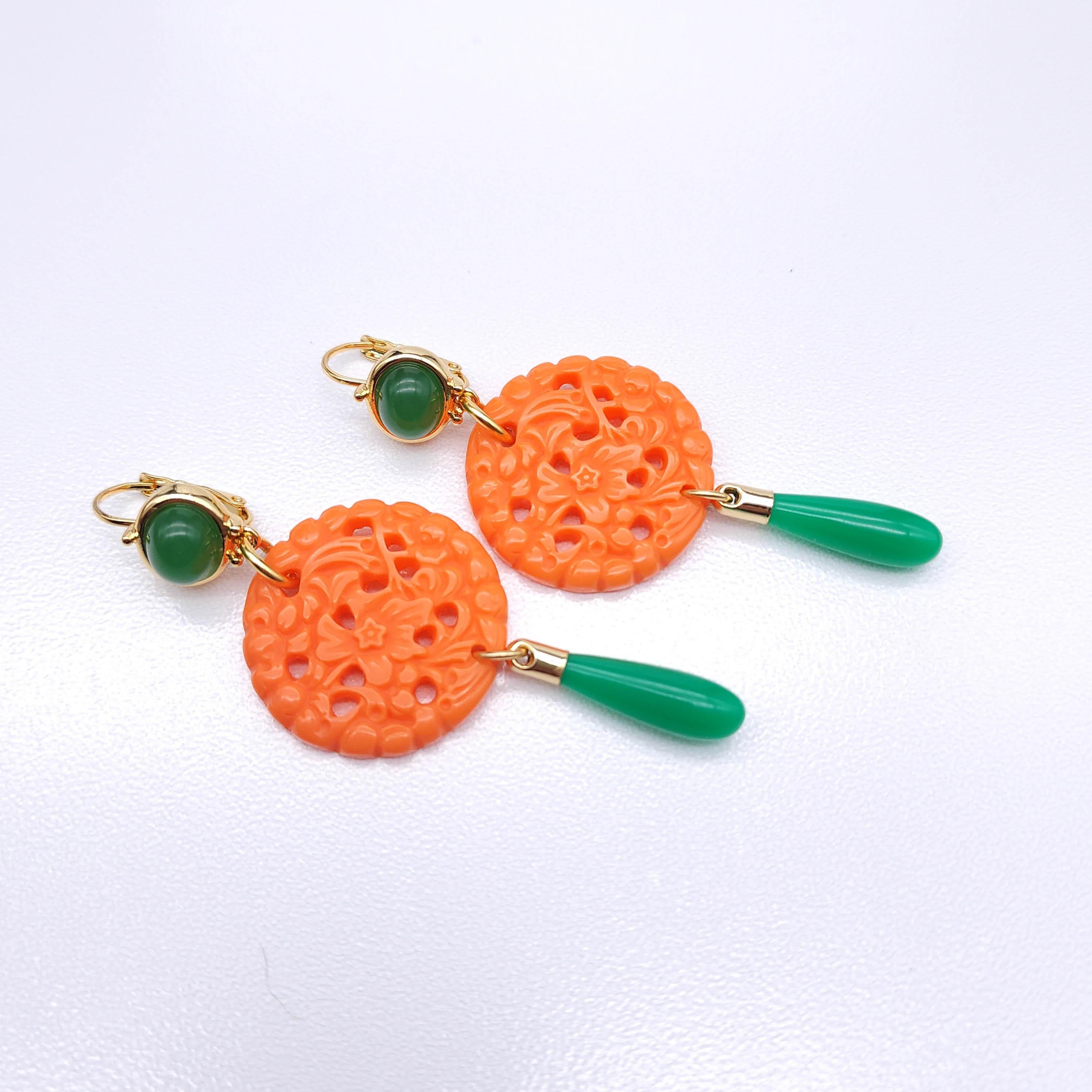 Enhance your style with these Kenneth Jay Lane earrings from the Couture Collection! Featuring sophisticated faux coral round pendants with intricate carved patterns and vibrant jade-green teardrop accents, these earrings make a striking statement.