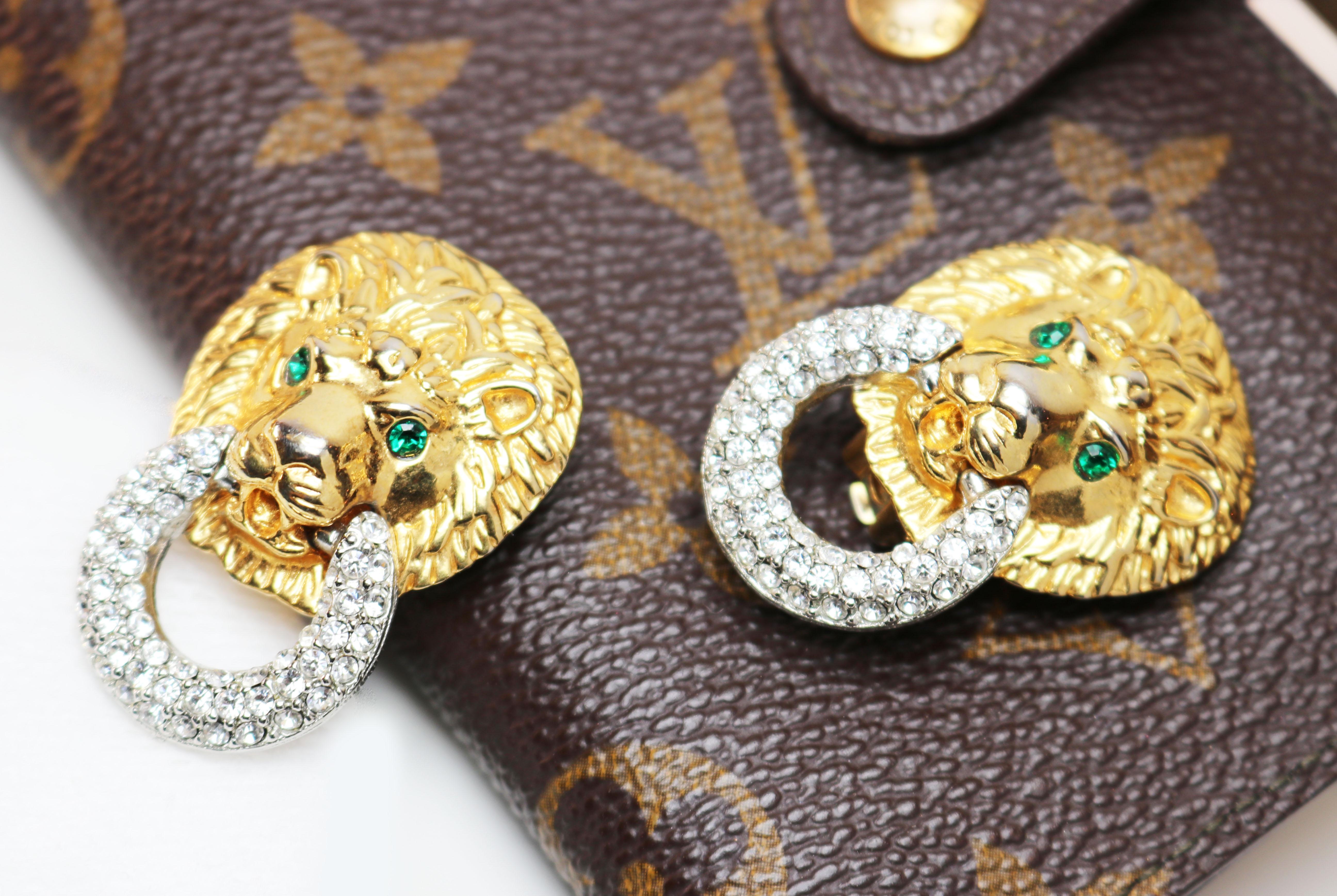 These chic, couture designer earrings with Diamanté Swarovski Crystals, in silver tone door-knockers, hanging from detailed lion's heads, in gold tone, with bright, emerald green Diamanté Swarovski Crystal eyes are in excellent condition and are