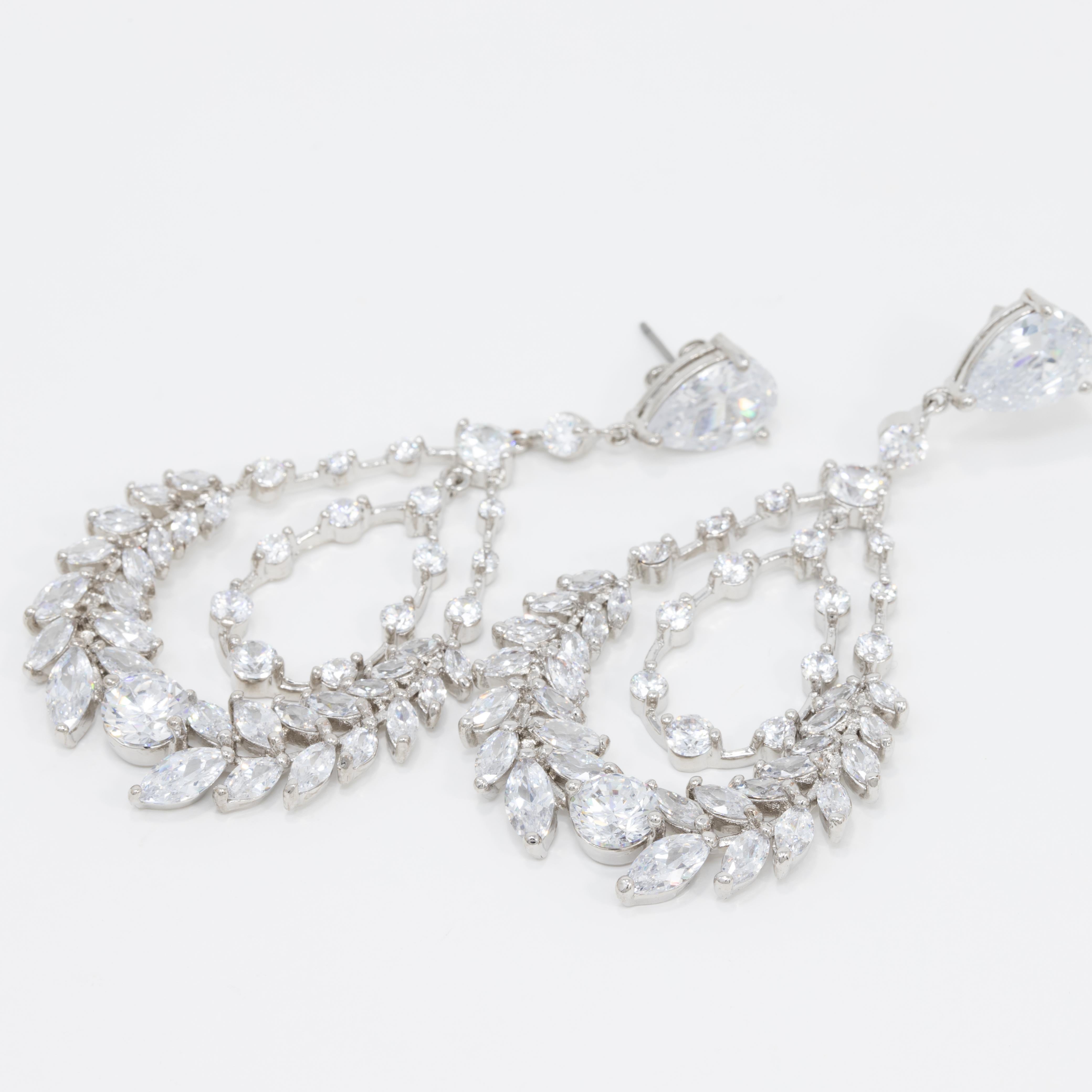 Marquise and round clear cubic zirconia crystals create this dazzling drop design worthy of a red carpet event. Dangle earrings by Kenneth Jay Lane.

CZ by Kenneth Jay Lane line.

Rhodium Plated Brass. Post with friction.

Tags, Marks, Hallmarks: