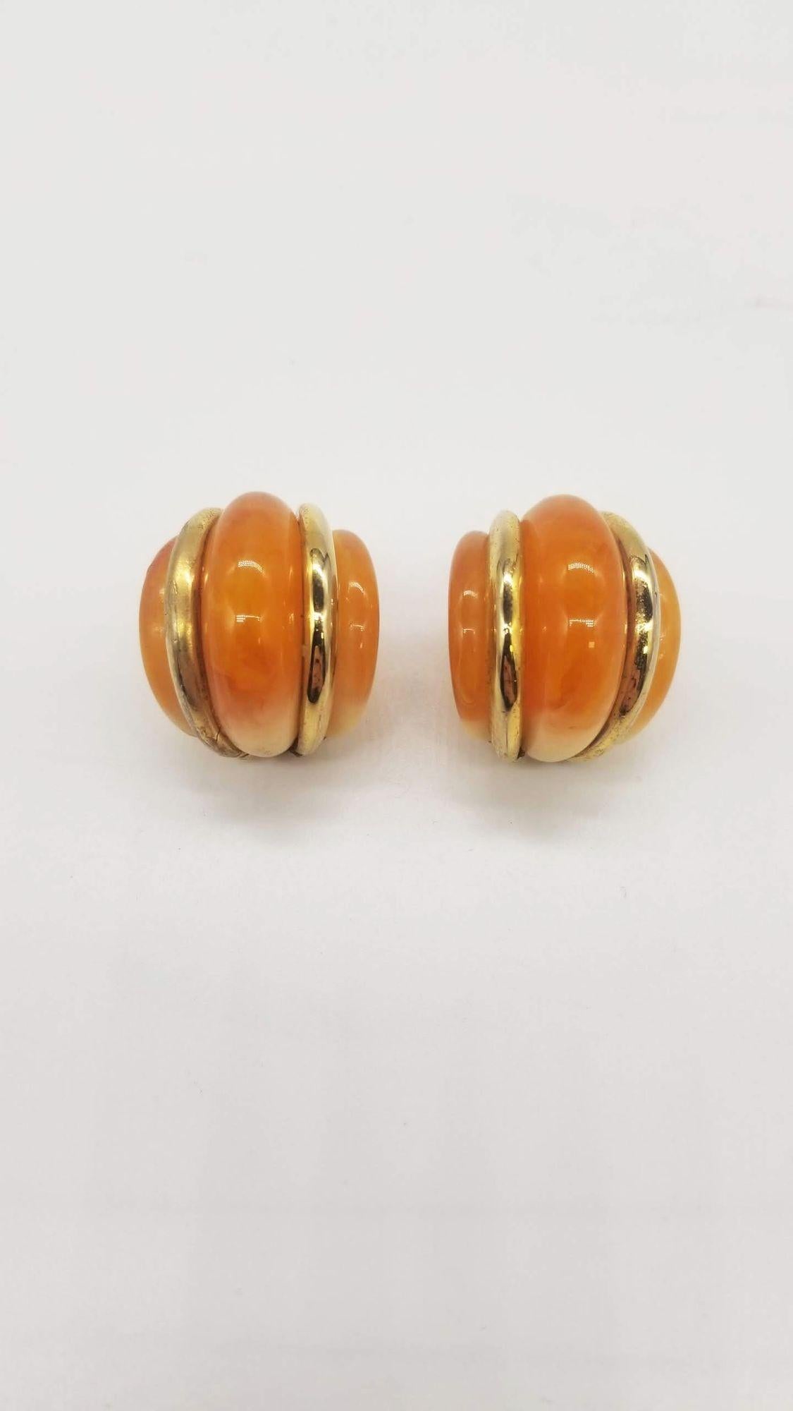 Elevate your jewelry collection with the Kenneth Jay Lane Double Ribbed Domed Clip-On Earrings, a perfect fusion of opulence and contemporary design. Crafted from luxurious gold-tone metal and adorned with rich resin detailing, these earrings exude