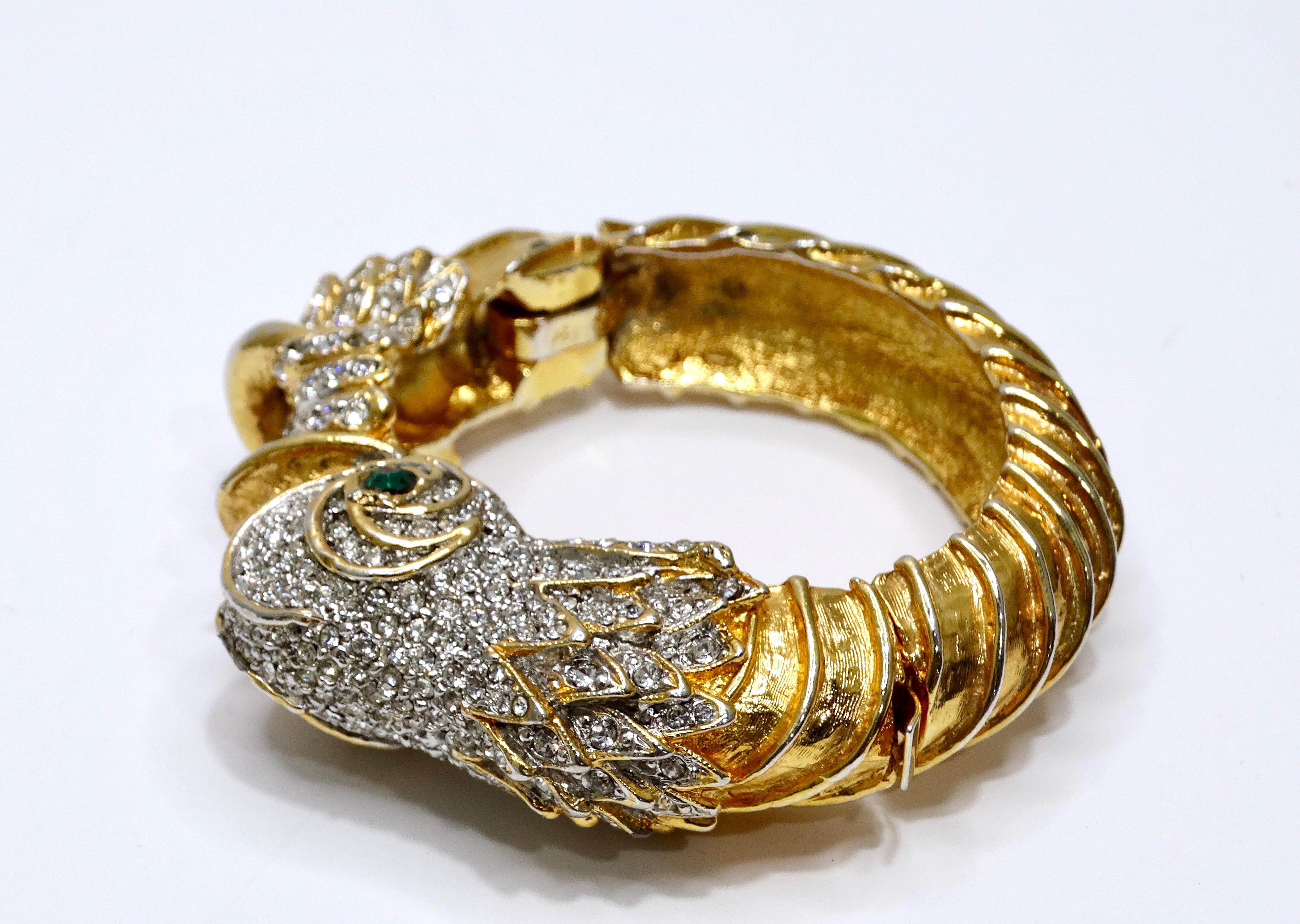 Kennth Lane is one of the most known jewelry designers in the United States and put intricate detail into this statement bracelet. Details feature a white and emerald green crystal embellished fish head, a highly textured band, and a clamp closure.